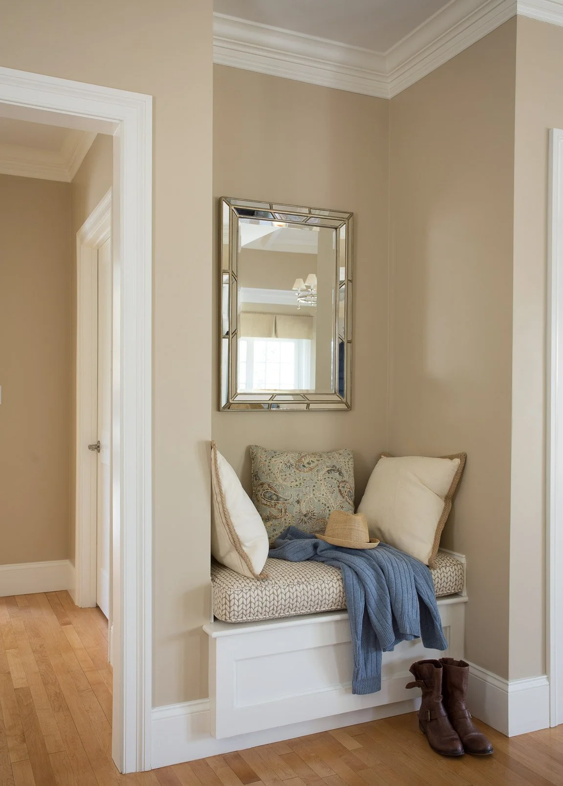 West Newton seating area in mudroom with upholstered seating, rug-based palette, warm wood tones, and mixed patterns.