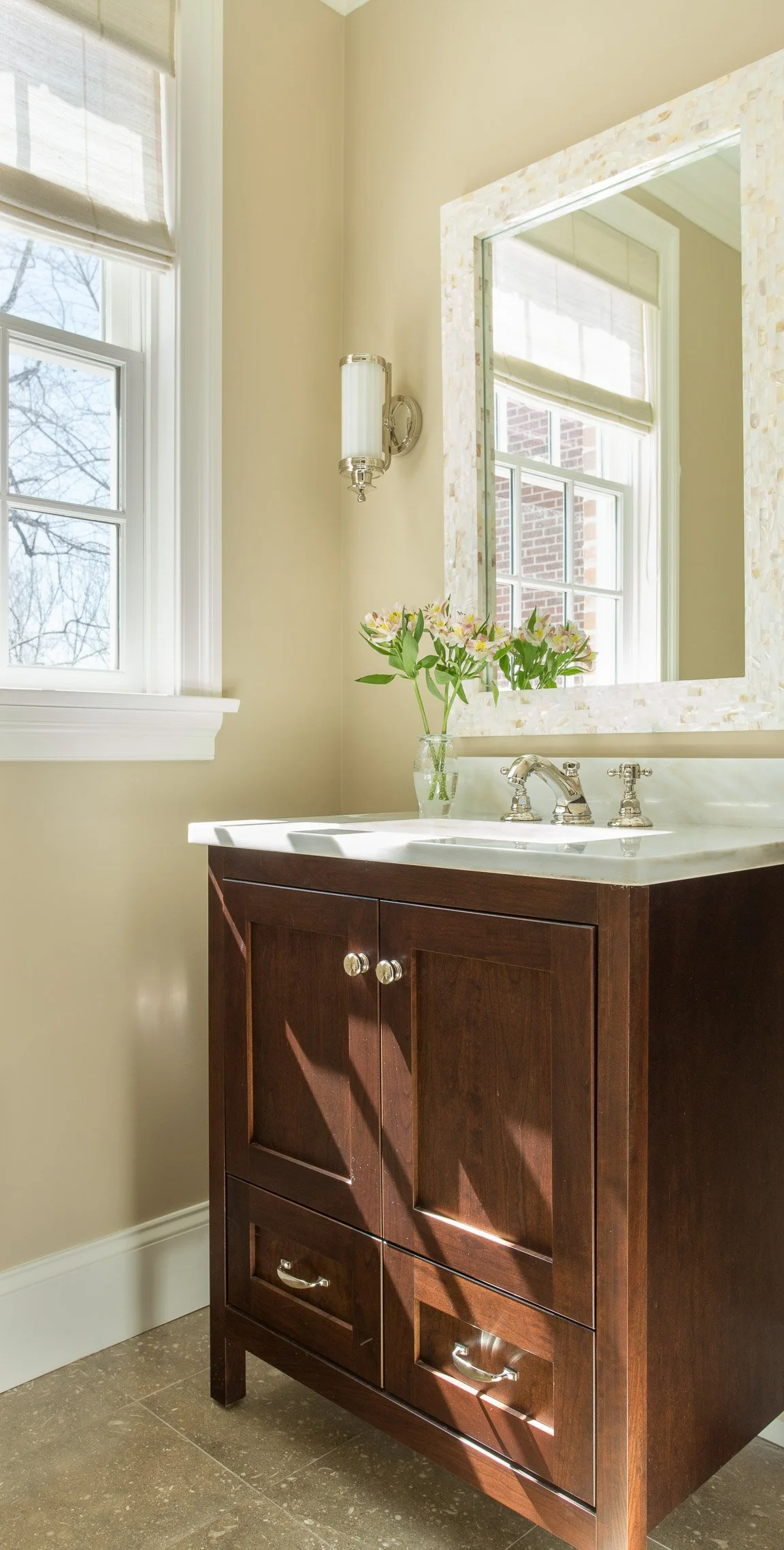 West Newton powder room with patterned wallpaper, simple vanity, warm metal accents, and layered lighting.