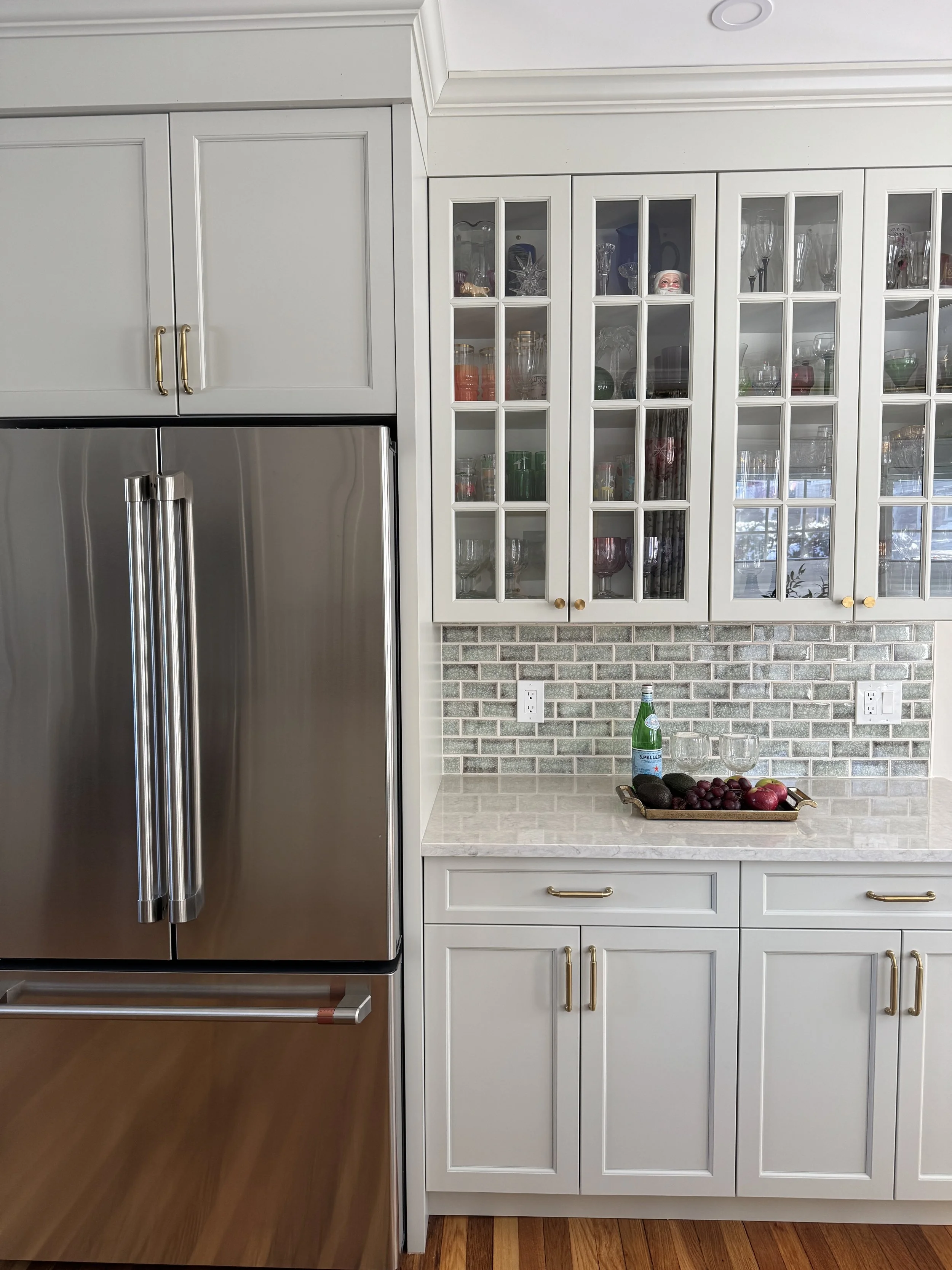 Custom kitchen cabinetry with built-in hutch and integrated refrigerator providing storage and display for glassware