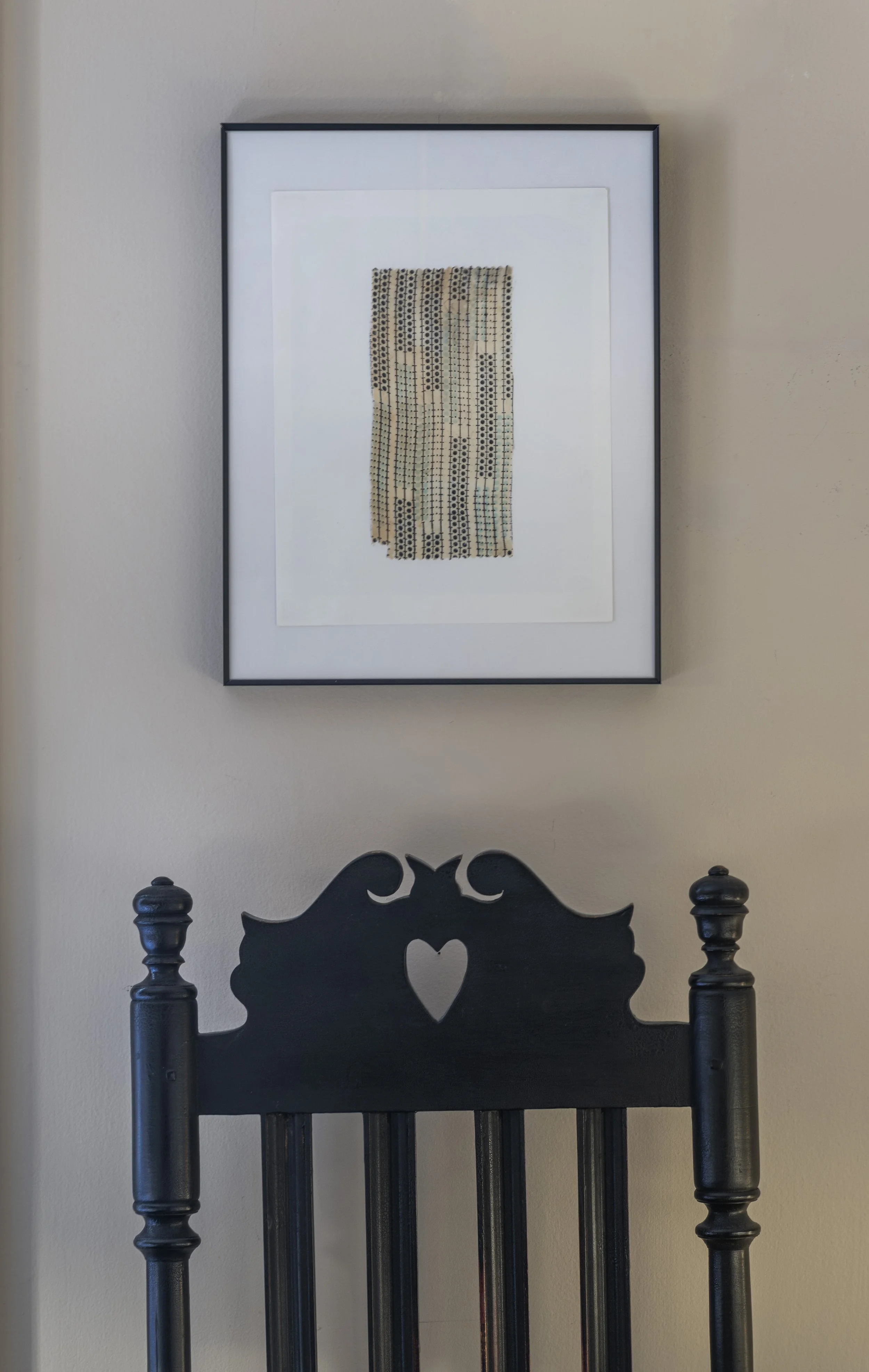 Vintage framed textile above Black William and Mary Bannister Back chair