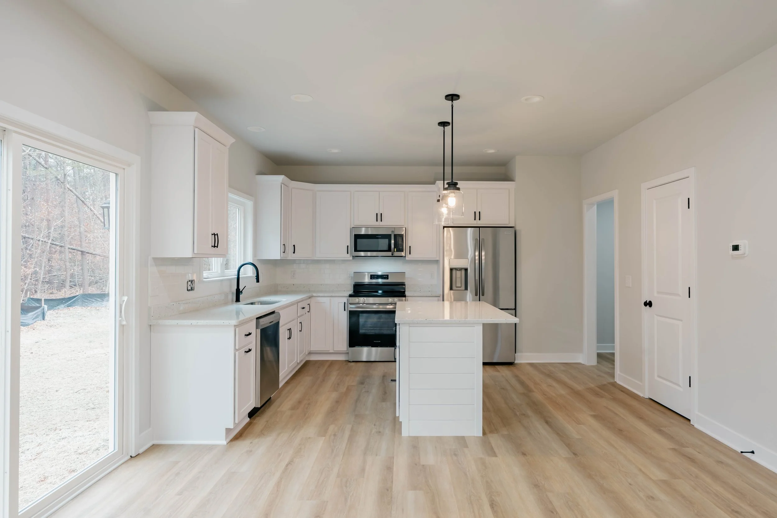 Gourmet custom kitchen in Stafford, VA, featuring a granite island, soft-close shaker cabinetry, and designer pendant lighting by R&W Homes.