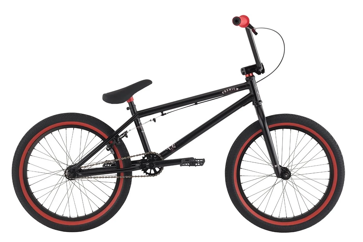 Black BMX bike with red accents on the tires, seat, and handlebars, isolated on a white background.