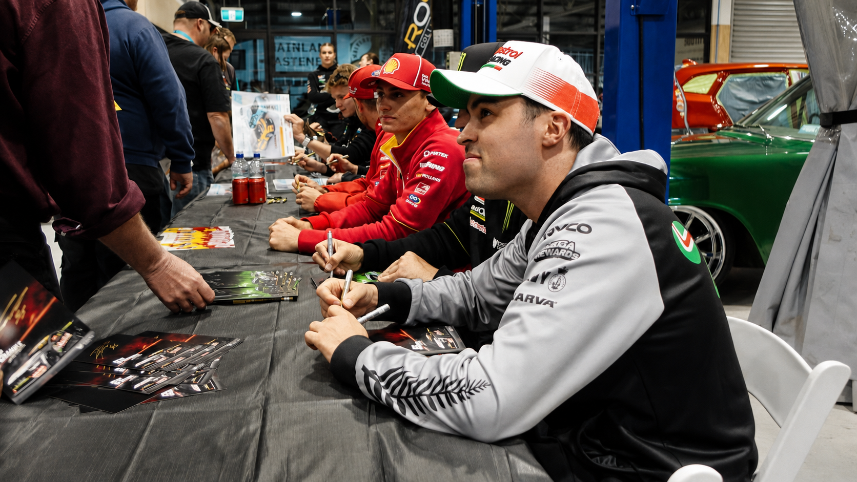 Supercars drivers lined up and signing autographs for fans