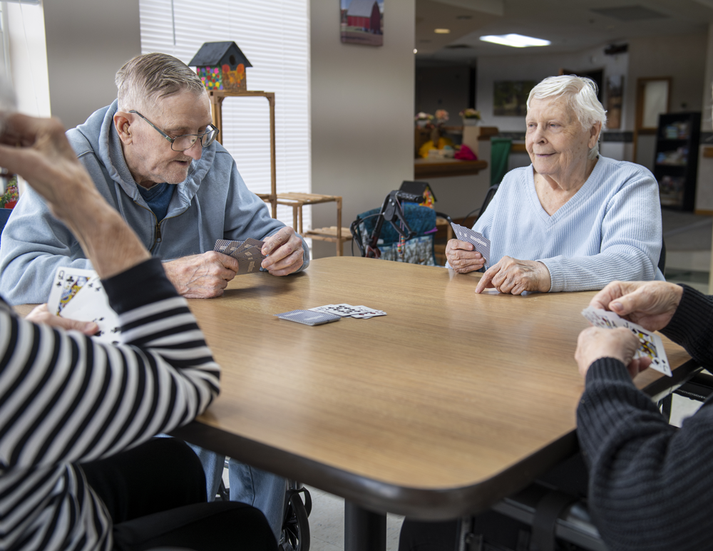 Four residents playing cards during a therapeutic recreation activity at St. John's Nursing Home in Springfield Minnesota
