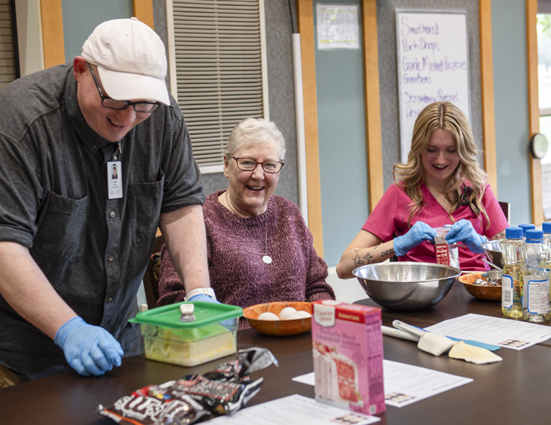 Nurse, activities assistant, and resident baking during therapeutic recreation at The Maples Assisted Living in Springfield MN