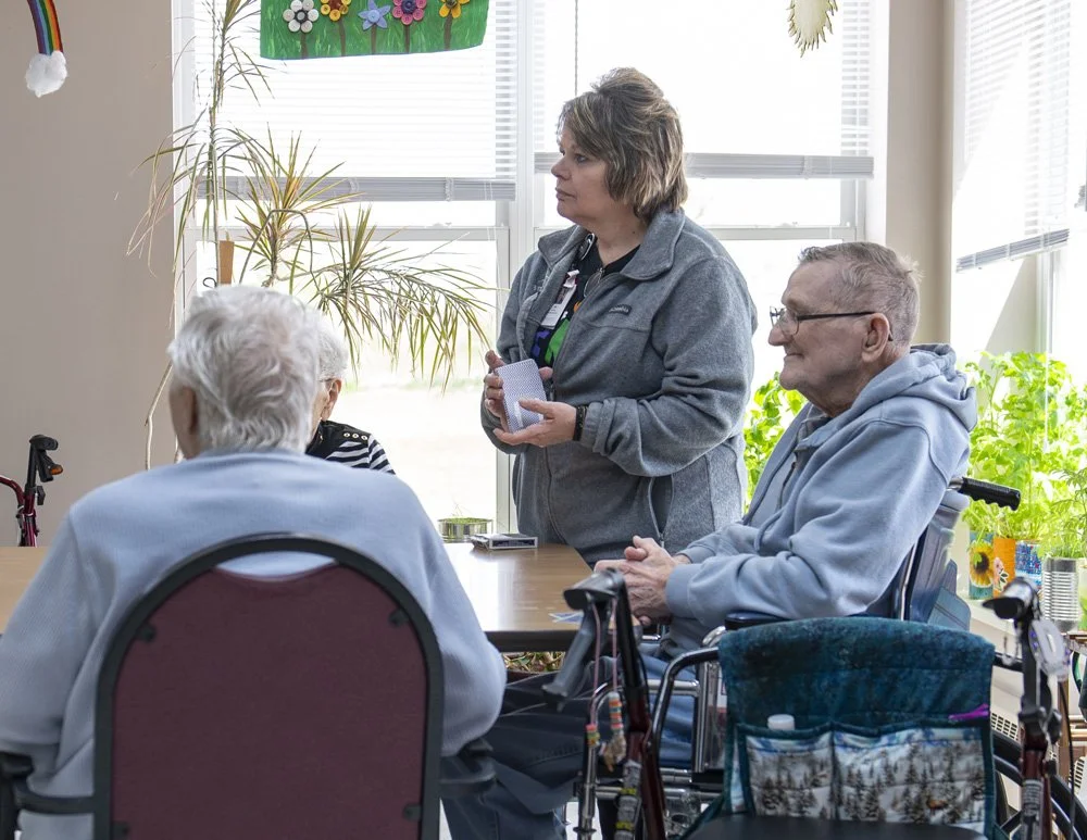 Residents enjoy playing card games with each other and staff