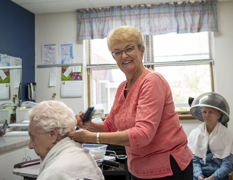 A volunteer giving a haircut to resident in the beauty salon at St. John's Nursing Home, southwest Minnesota