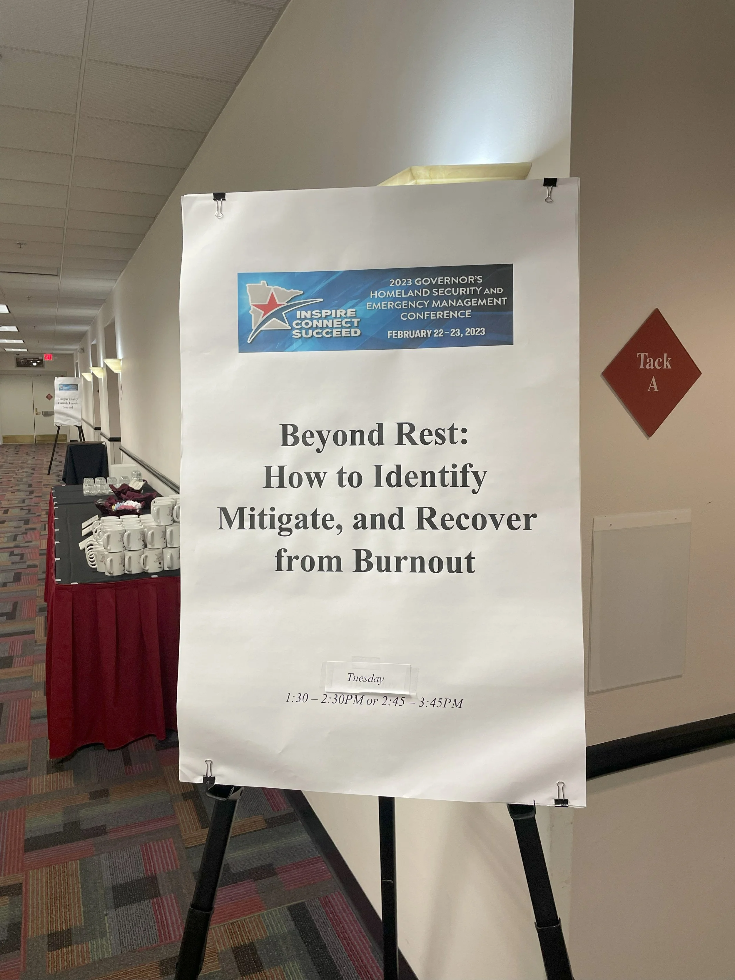 Conference sign displaying the title of a session on burnout at the 2023 Governor's Homeland Security and Emergency Management Conference, scheduled for Tuesday with session times at 1:30 to 2:30 PM or 2:45 to 3:45 PM.