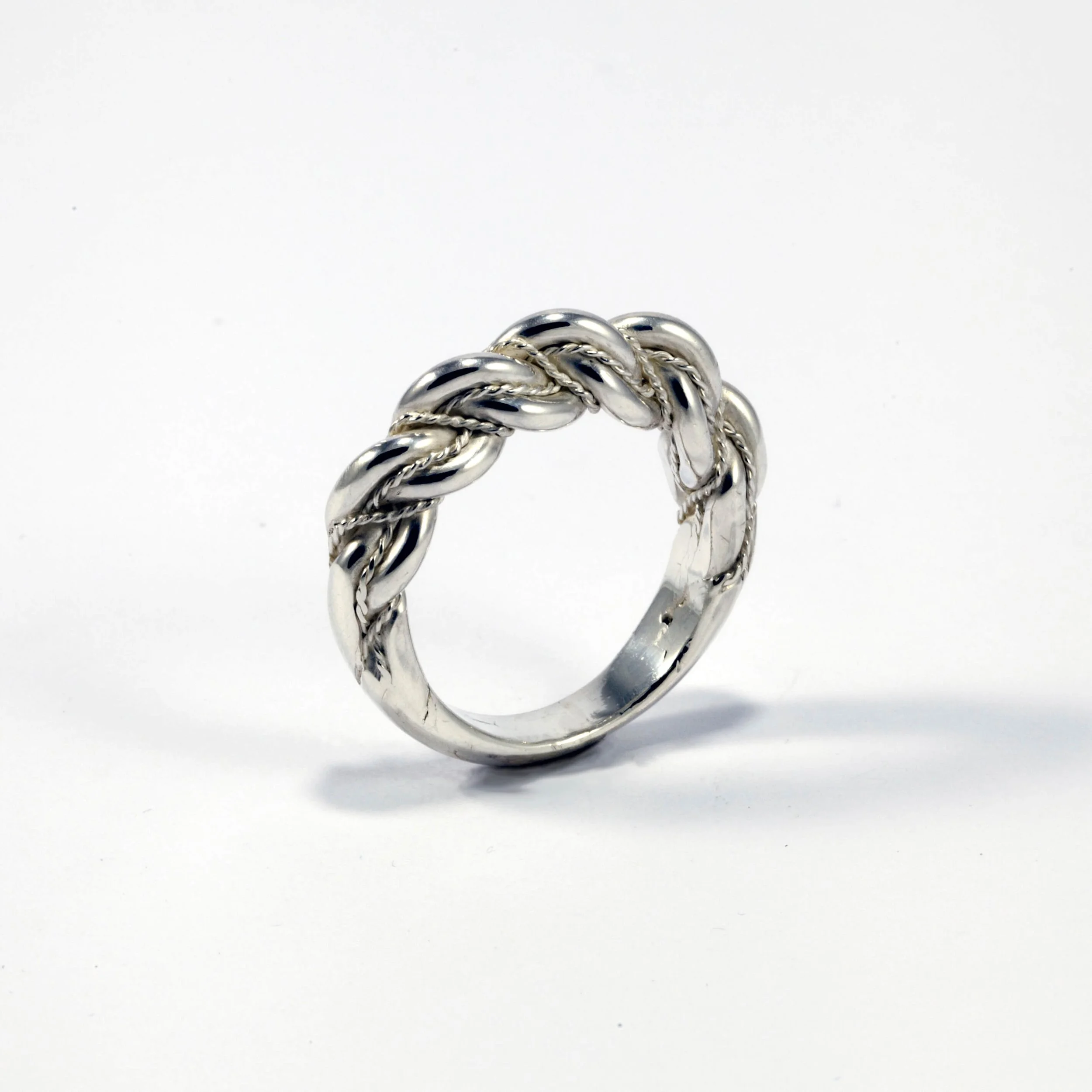 Silver ring with a twisted rope design on a white background.
