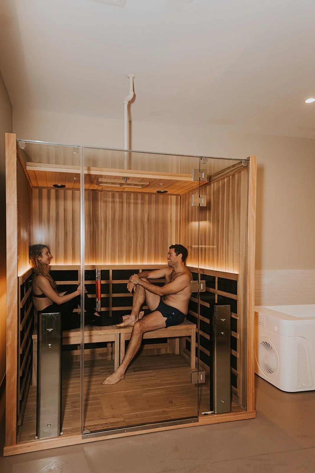 couple in infrared sauna next to cold plunge
