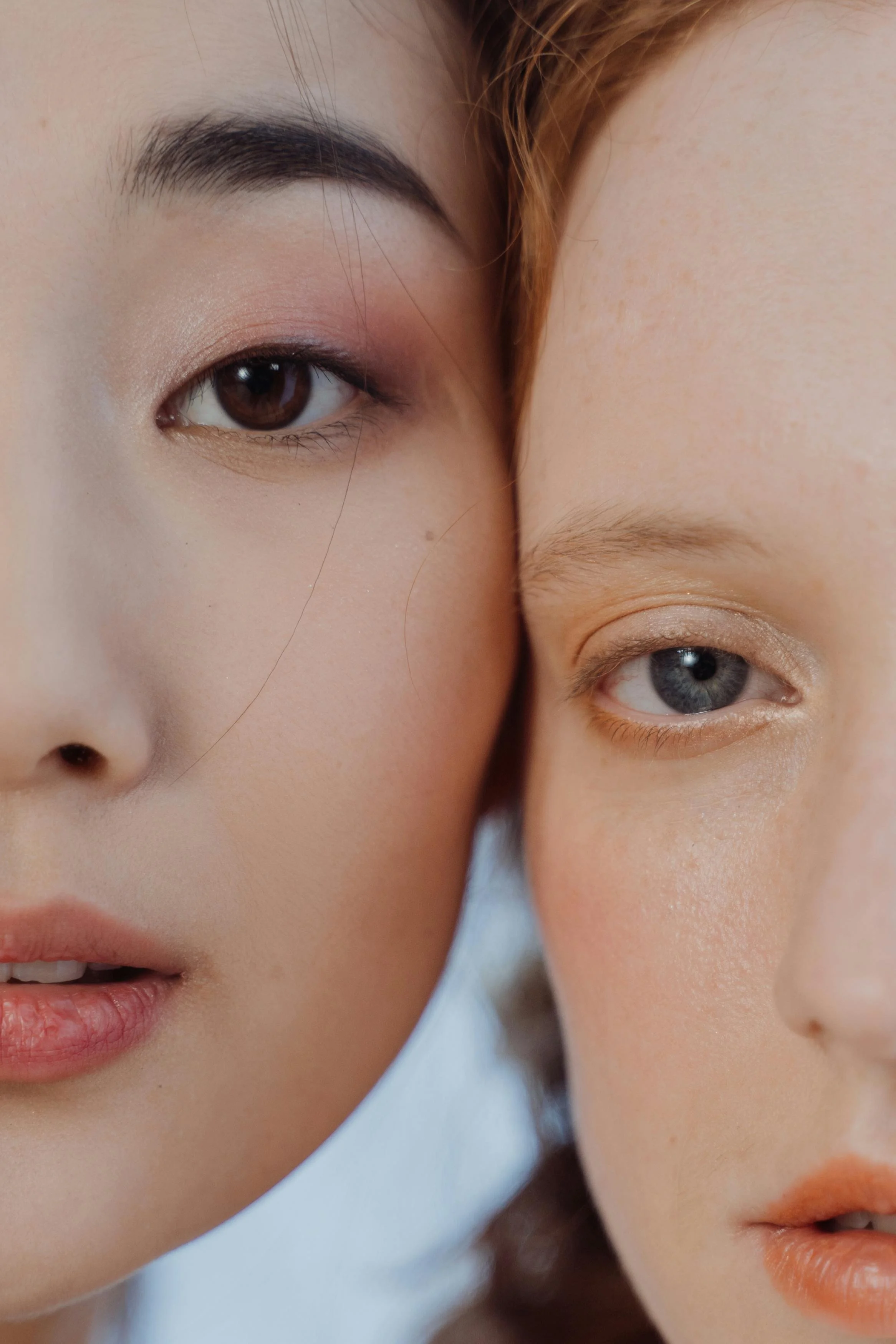 Close-up of two women's faces, focusing on their eyes and lips, with the woman on the left having an Asian appearance and the woman on the right having a Caucasian appearance.