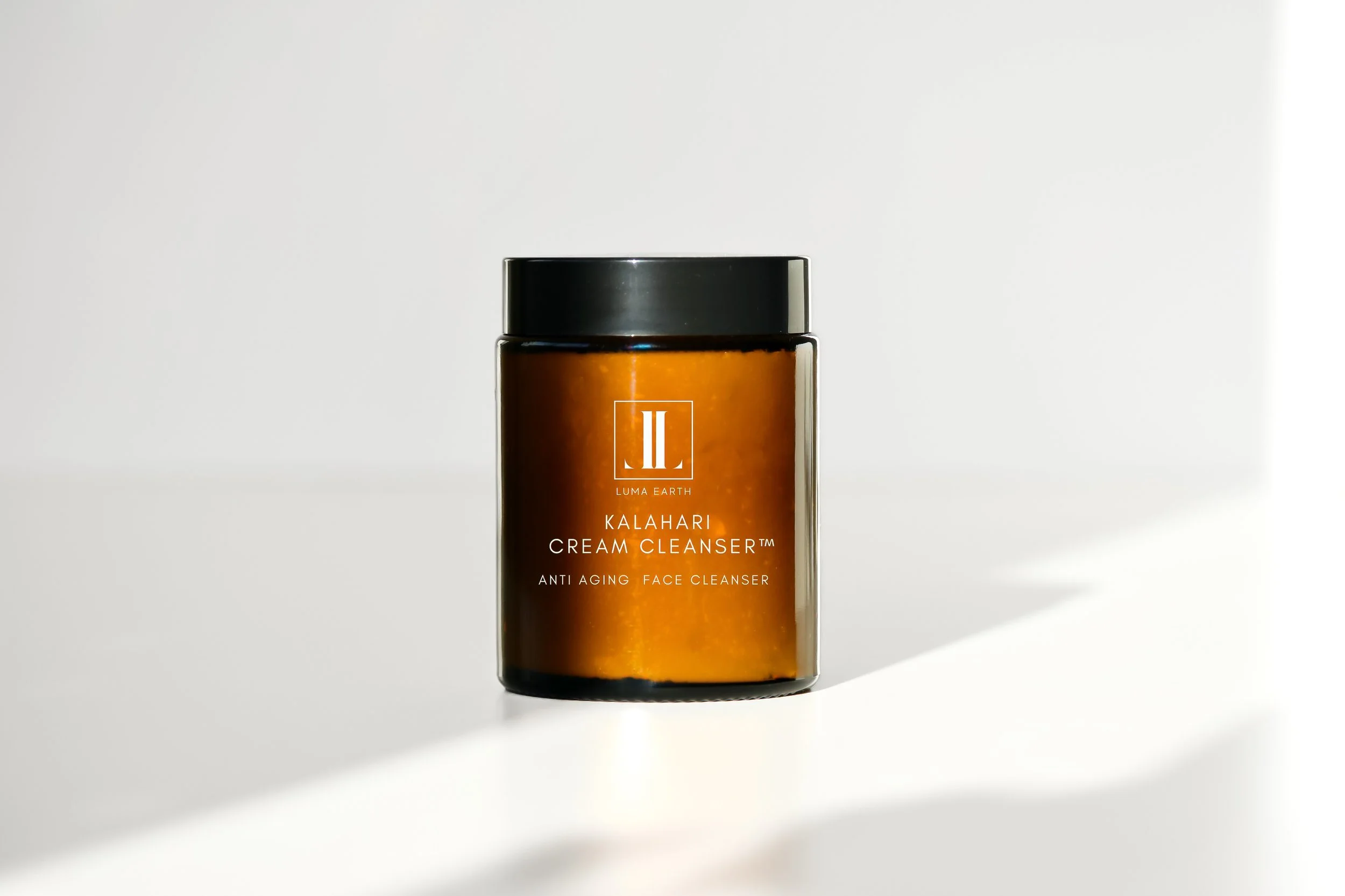 Amber-colored jar of Luma Earth Kalahari Cream Cleanser against a white background with shadow.