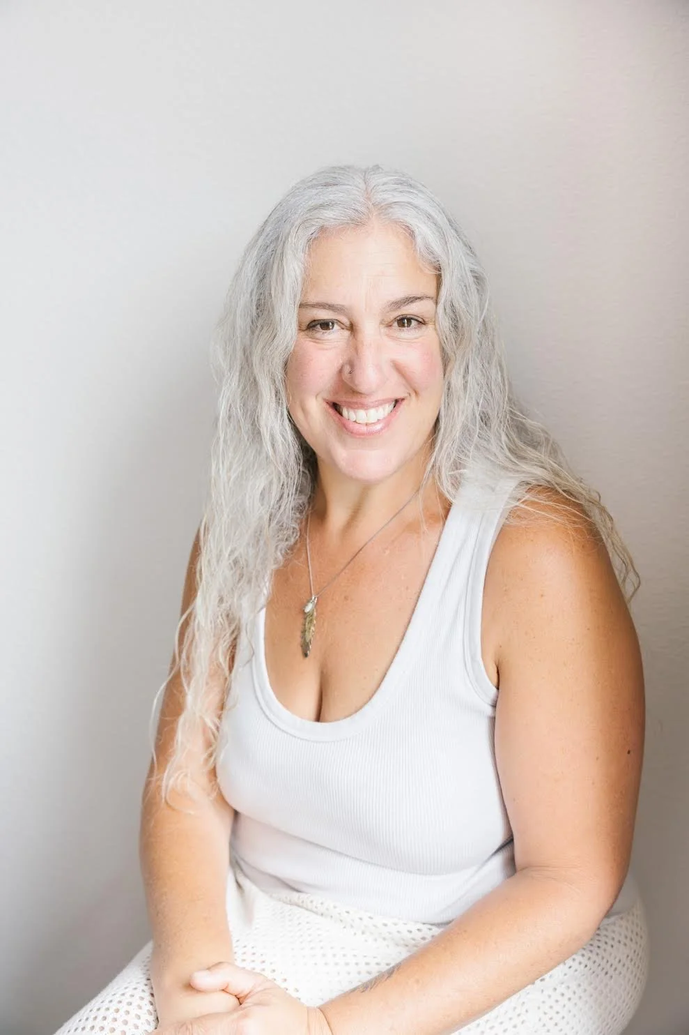 Woman with grey long hair smiling.
