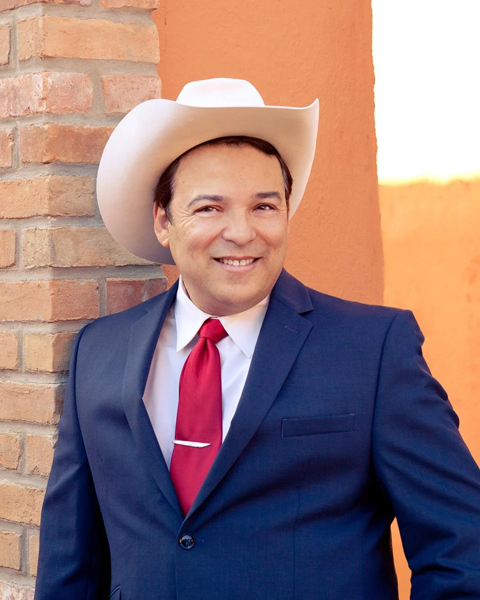 Photo of western swing crooner Billy Mata in a suit and cowboy hat smiling for a promotional photo