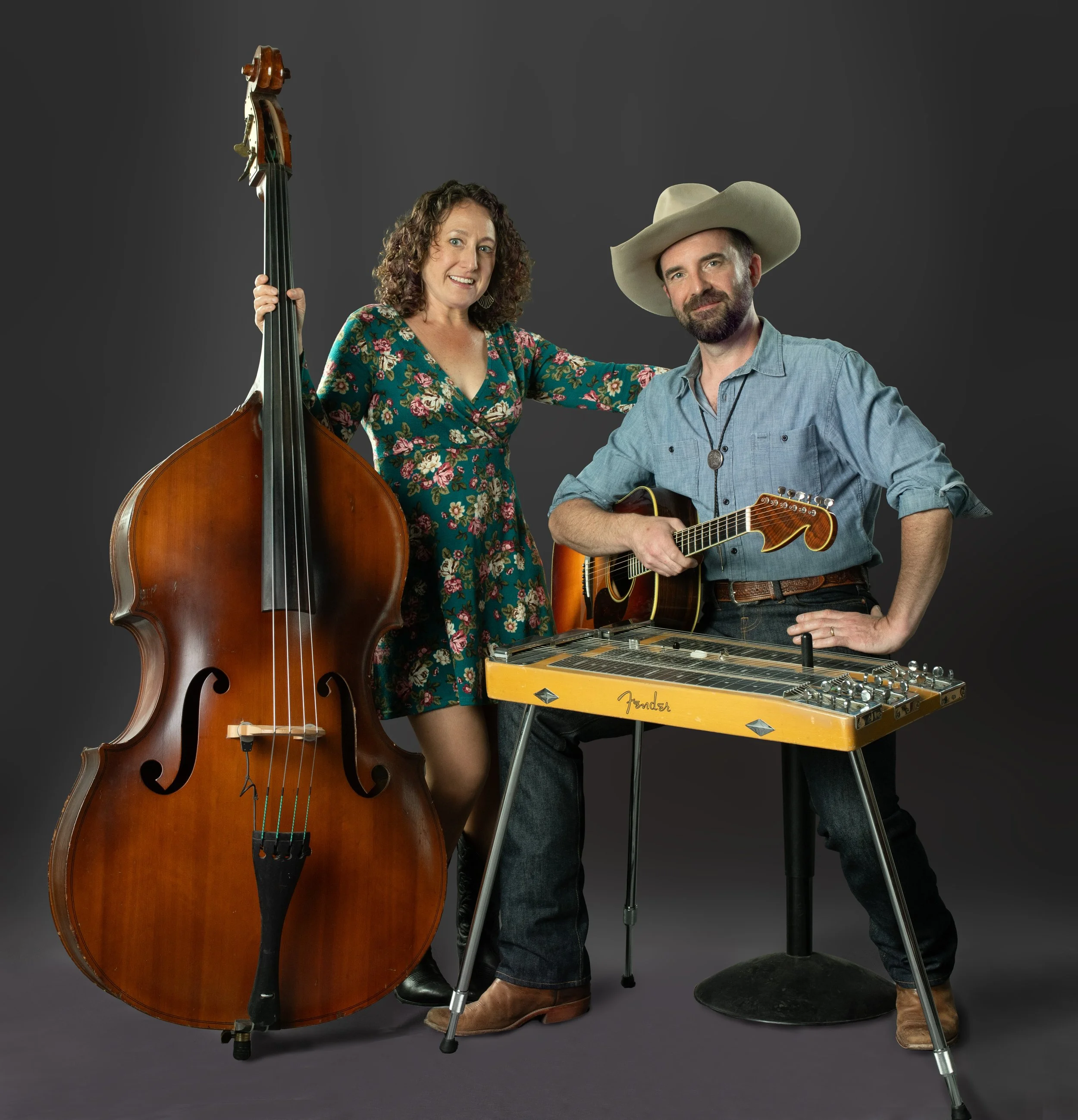 Carolyn Sills with her upright bass guitar along with Gerard Egan sitting with his guitar and steel guitar.