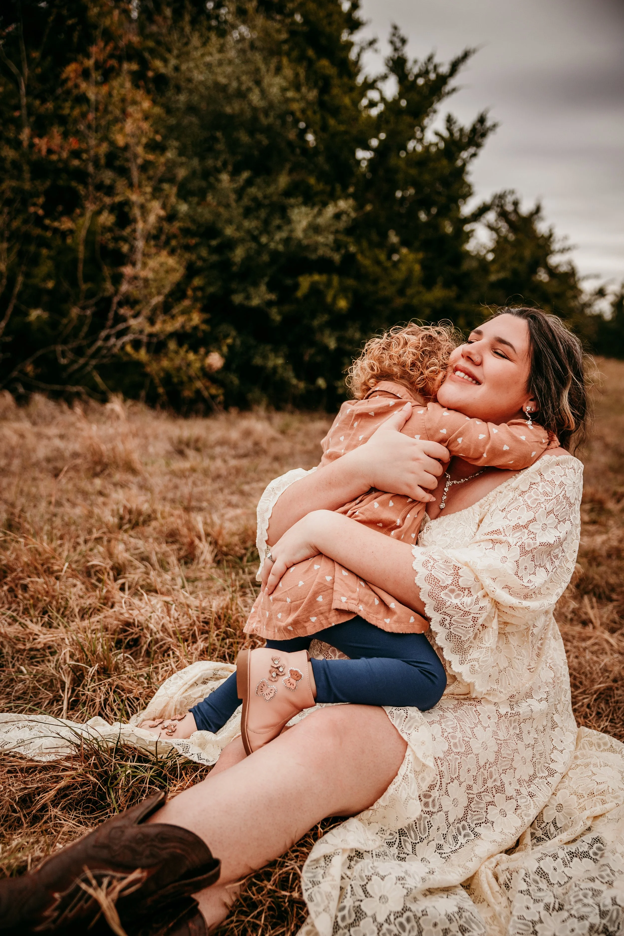 A woman and a young girl share a joyful hug outdoors on a fall day who is the best available doula near me in bryan and college station texas