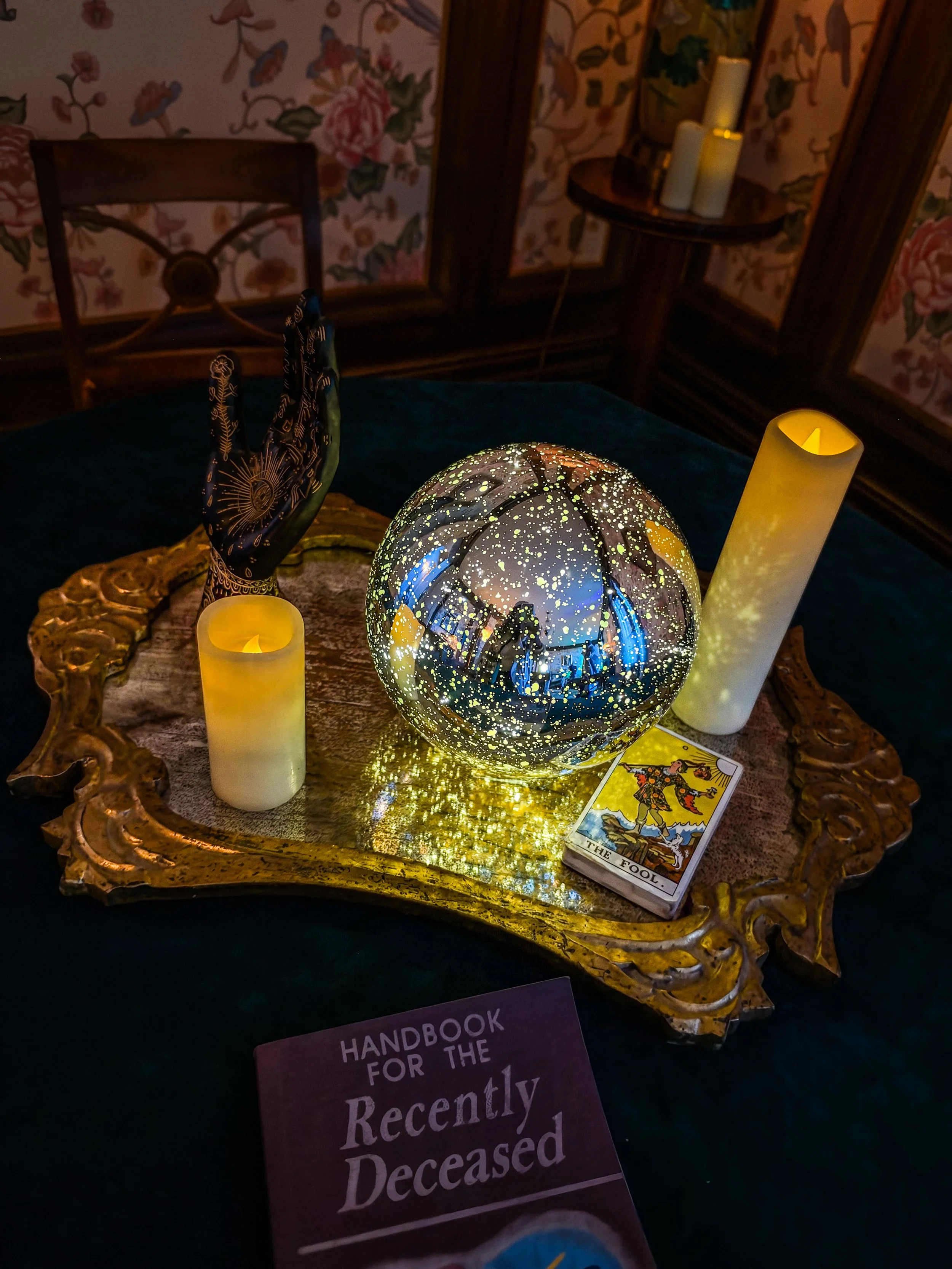 Illuminated crystal ball, tarot cards and candles surrounded by gothic Halloween décor inside Filoli’s Historic House during Nightfall.