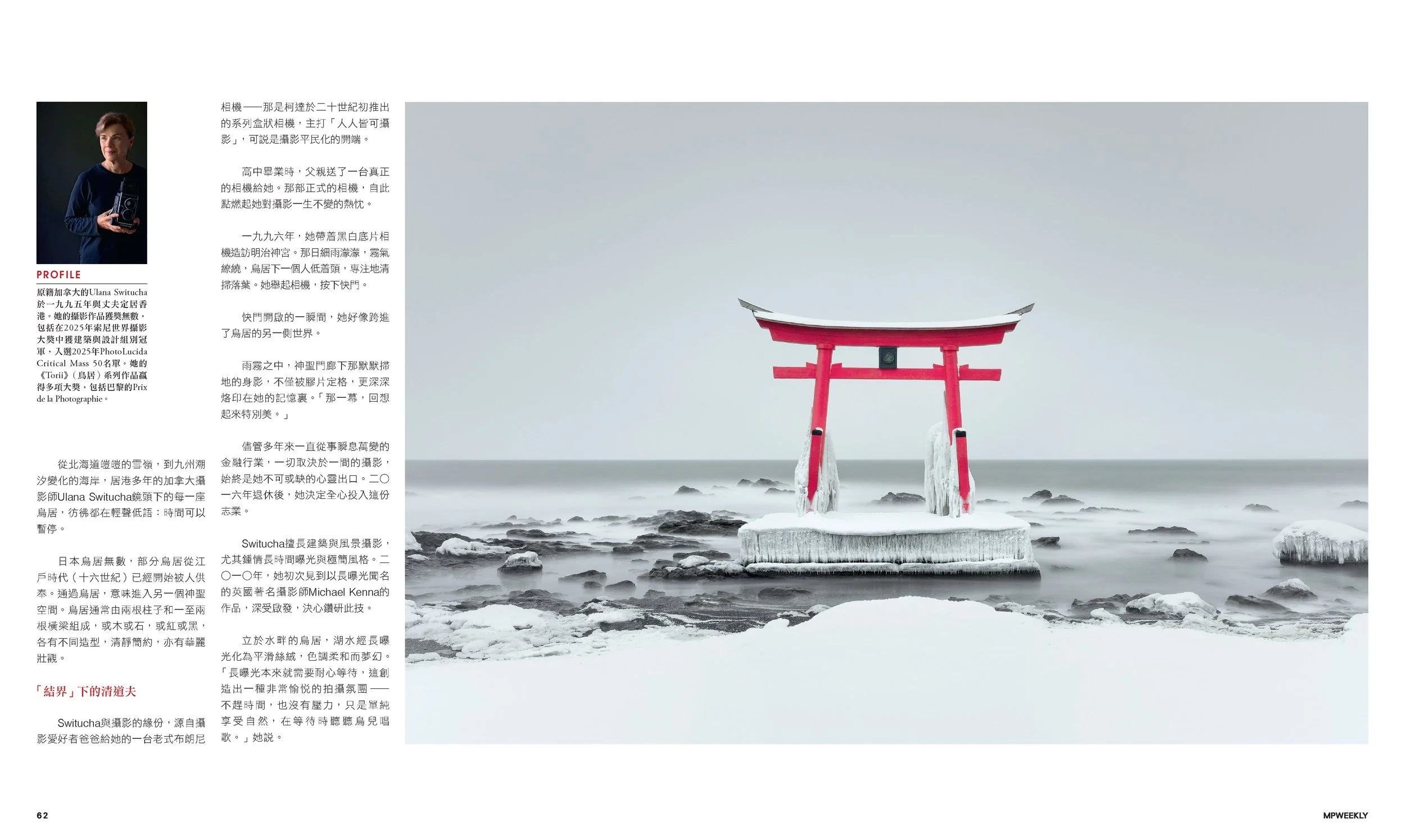 A photograph of a traditional Japanese torii gate in the ocean, covered in snow and ice, with rocks around its base and a stormy sky in the background.