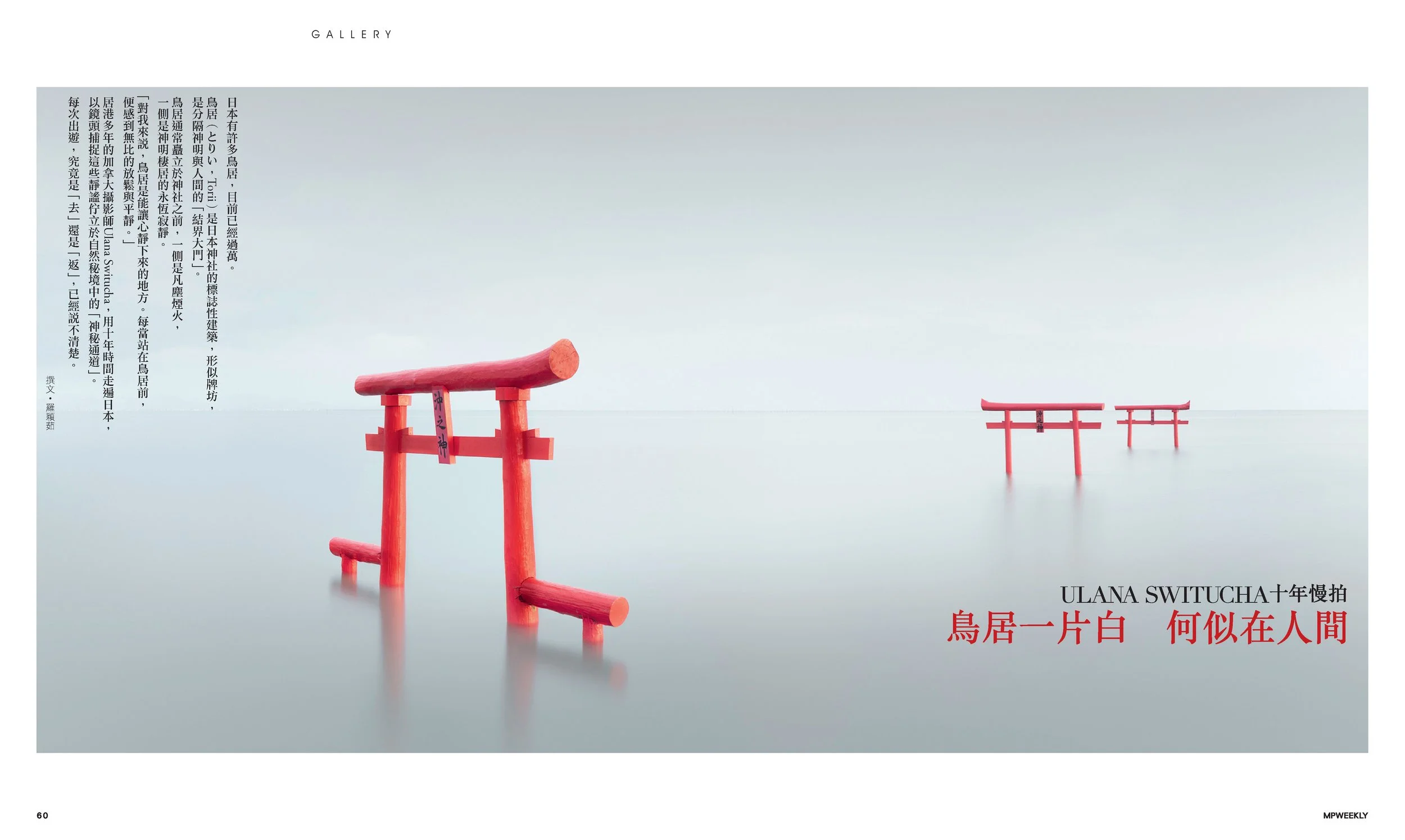 Photograph of several red torii gates standing in the water, creating a surreal scene with a misty or calm water surface and a light sky background.