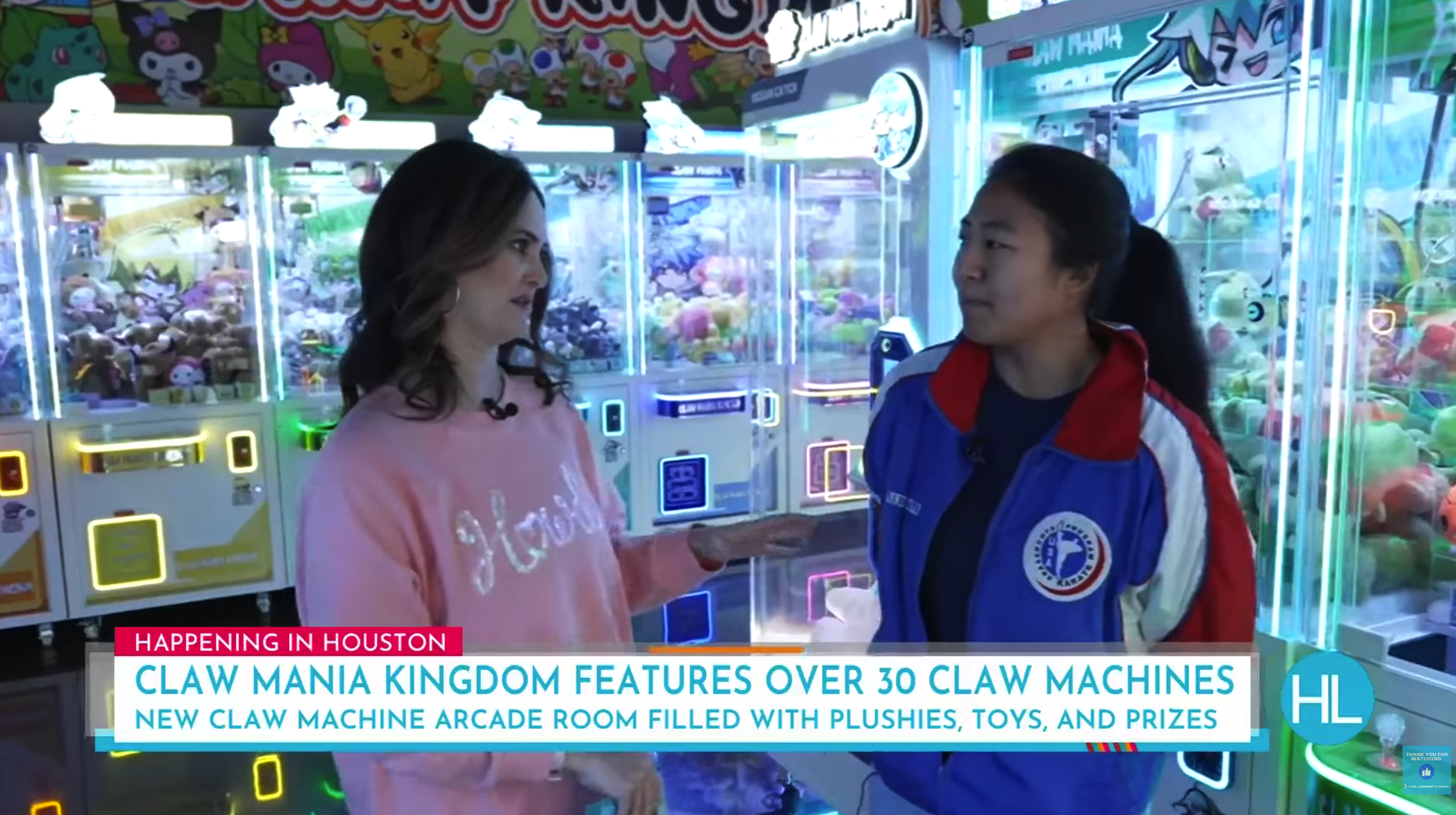 Two women conversing at an arcade with claw machines filled with plush toys, colorful arcade game lights, and cartoon character decorations overhead.