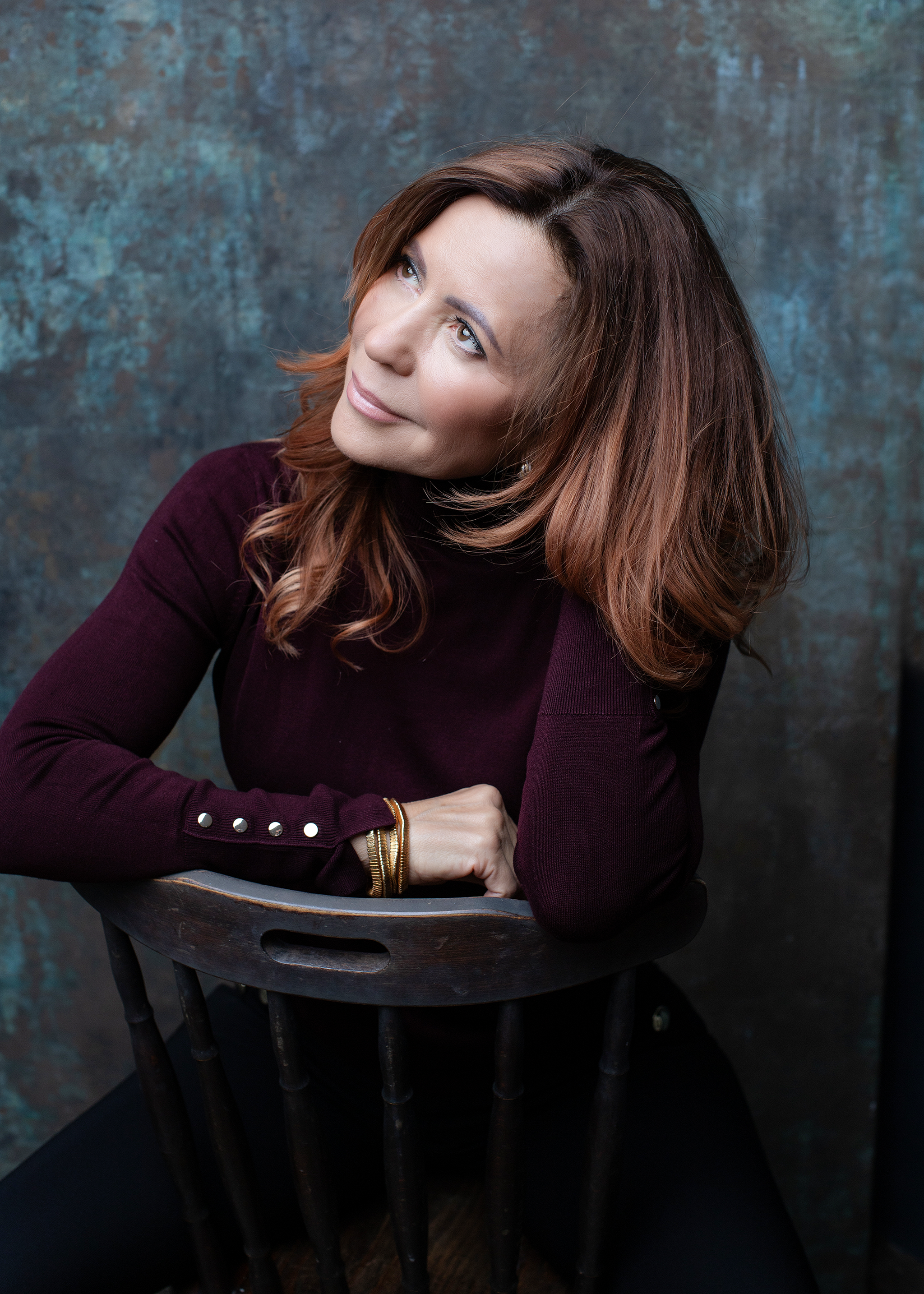 Dobrik Judit női coach, inspiráló pózban, sötétlila felsőben, önismereti coachinghoz. Portré egy nőről, aki karrierfejlesztés és belső erő erősítésére fókuszál.