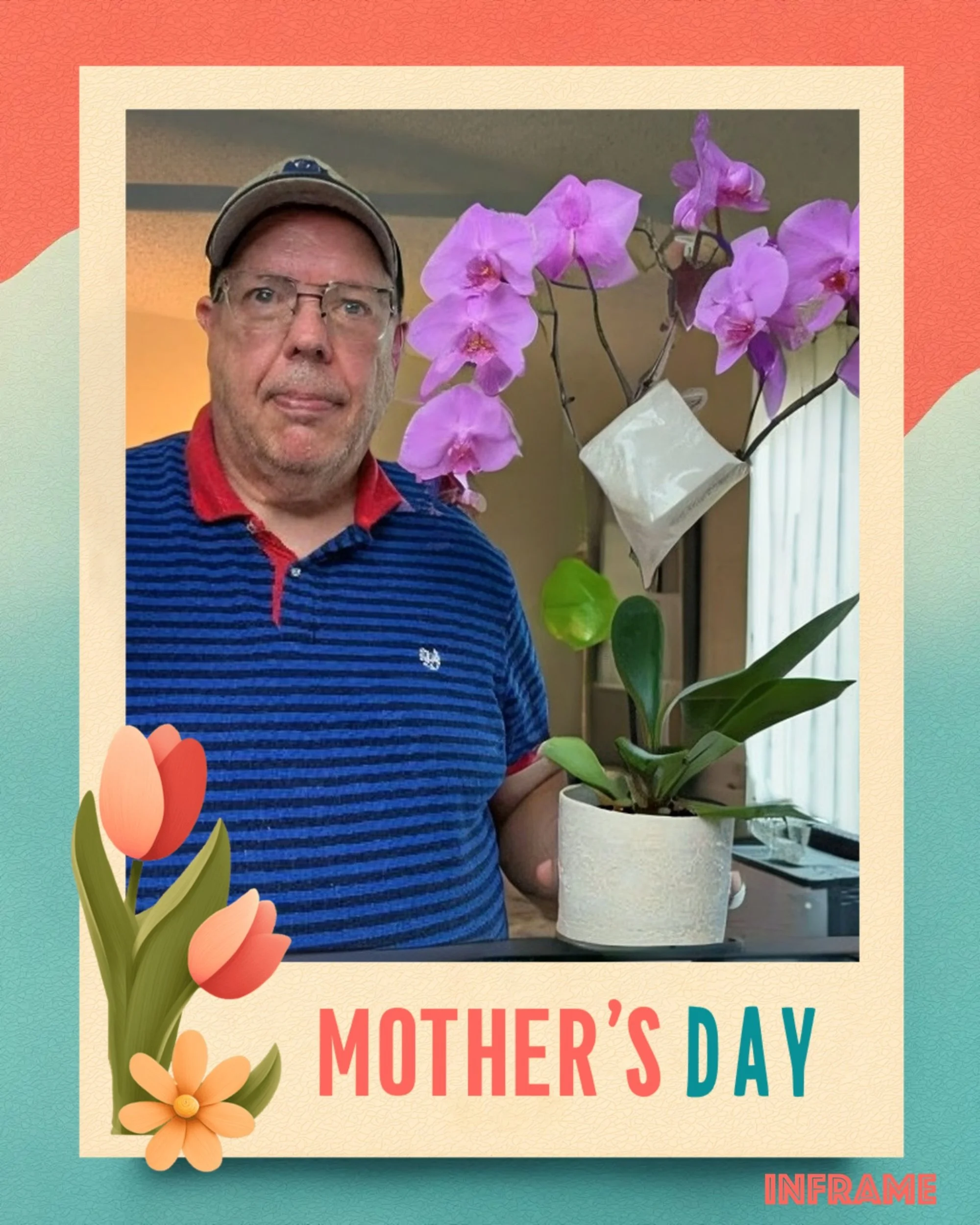A man in a striped blue shirt with a red collar, wearing glasses and a cap, standing indoors while holding a pot of pink orchids with green leaves.