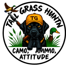 Logo featuring a black Labrador with a yellow hat, surrounded by grass, a duck, and a snake, with the text 'TALL GRASS HUNTING' and 'CAMO, AMMO, ATTITUDE'.
