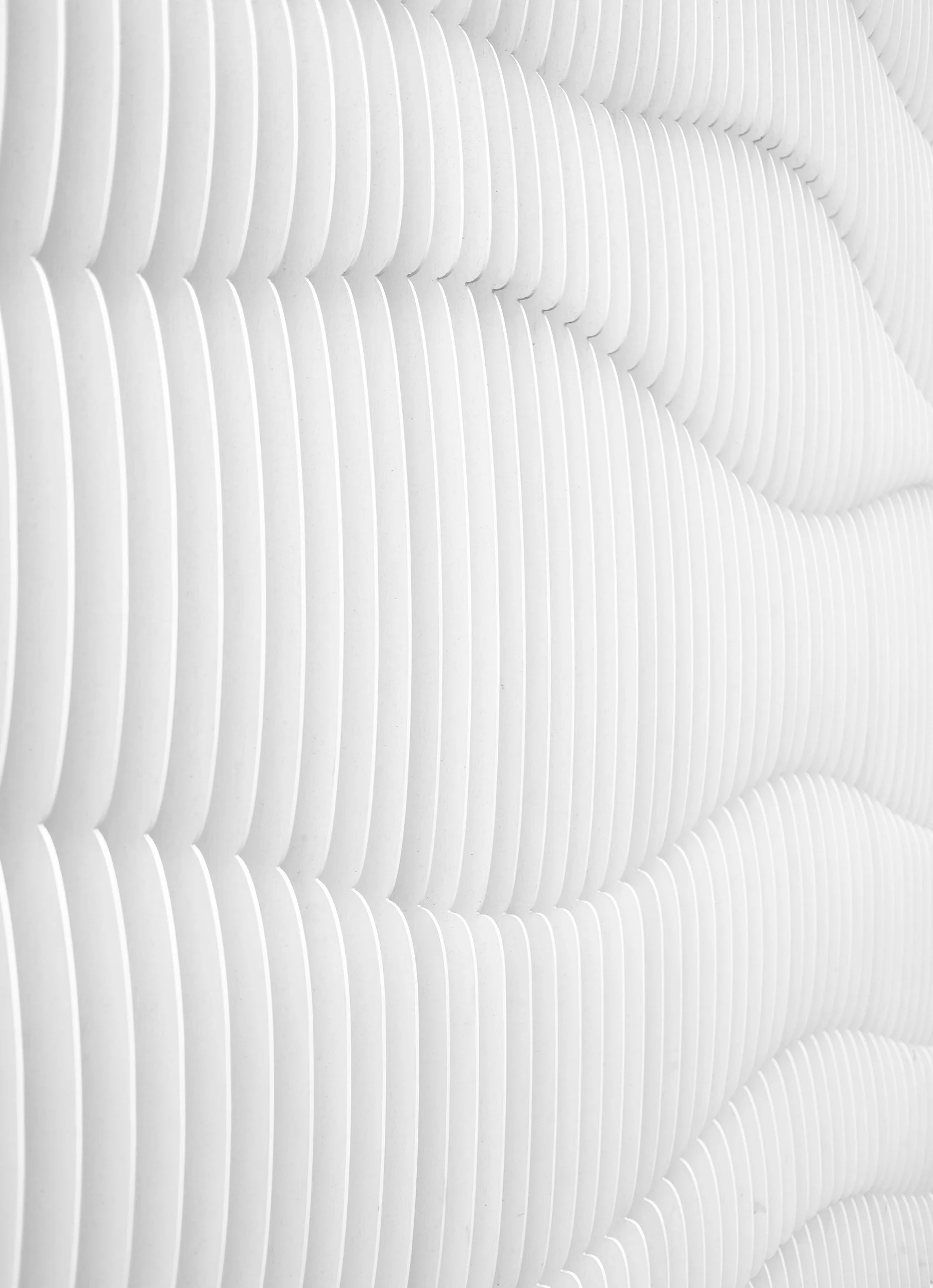Close-up of a modern, textured white wall with organic, wave-like patterns.
