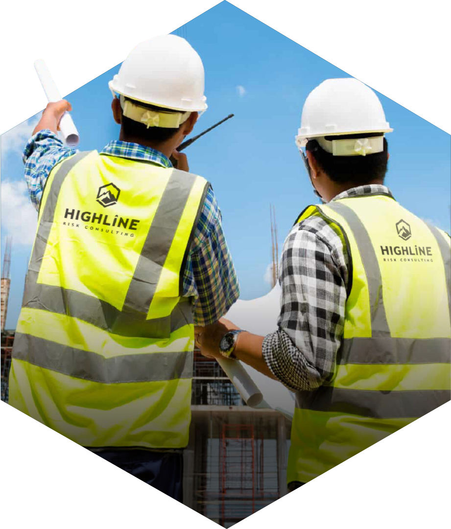 Highline Risk Consulting, Risk assessment, safety audit, ICAM audits, iauditor, ISO45001 policy, risk assessment. Two construction workers with helmets and high-visibility vests reviewing blueprints at a construction site on a sunny day.