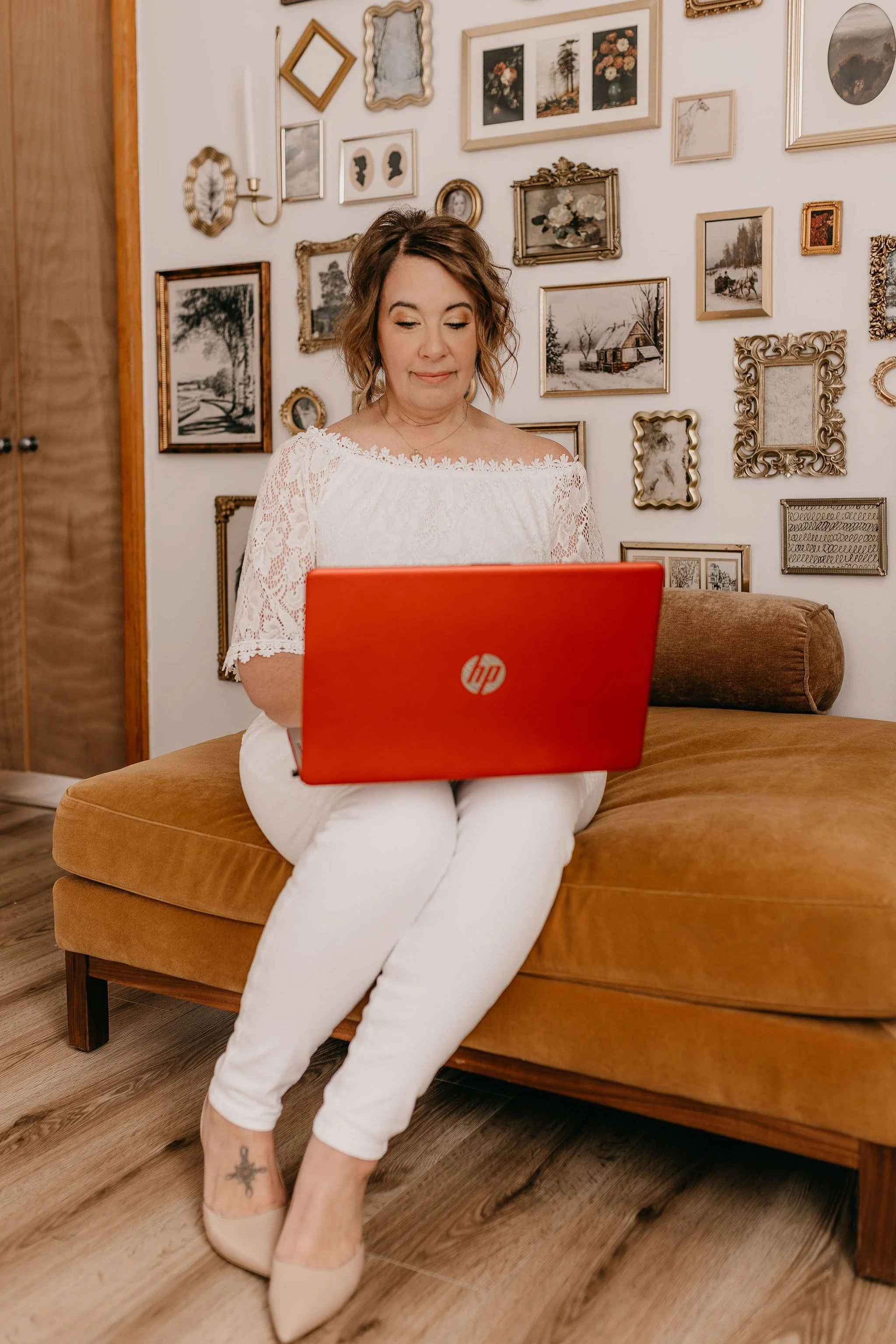 Melisa sitting on sofa with red laptop