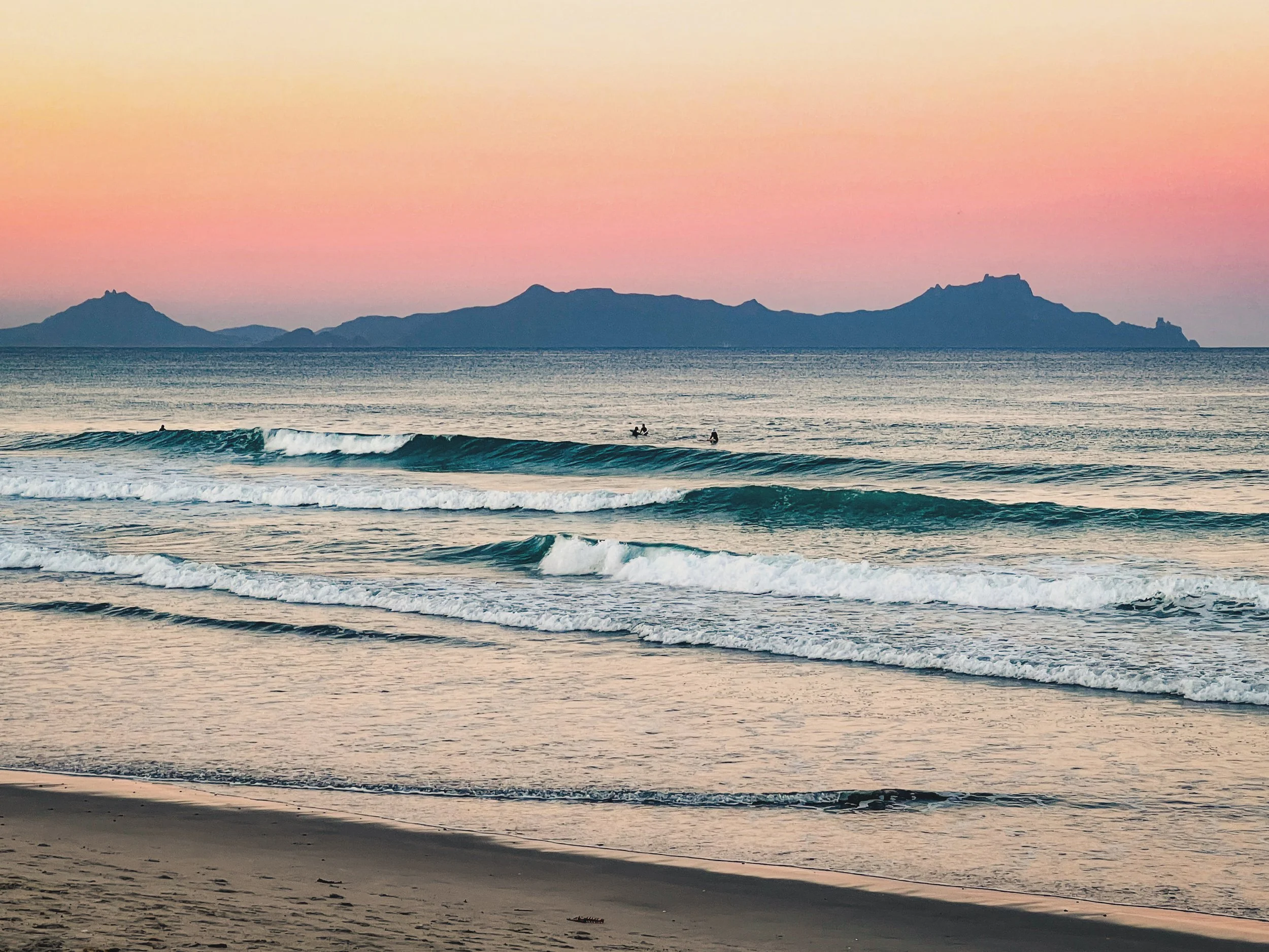 Stunning sunset view of ocean waves at Ruakaka looking towards Whangārei Heads, showcasing the Bream Bay lifestyle. Sell your Bream Bay property with James Alexander and Charlotte Daun.