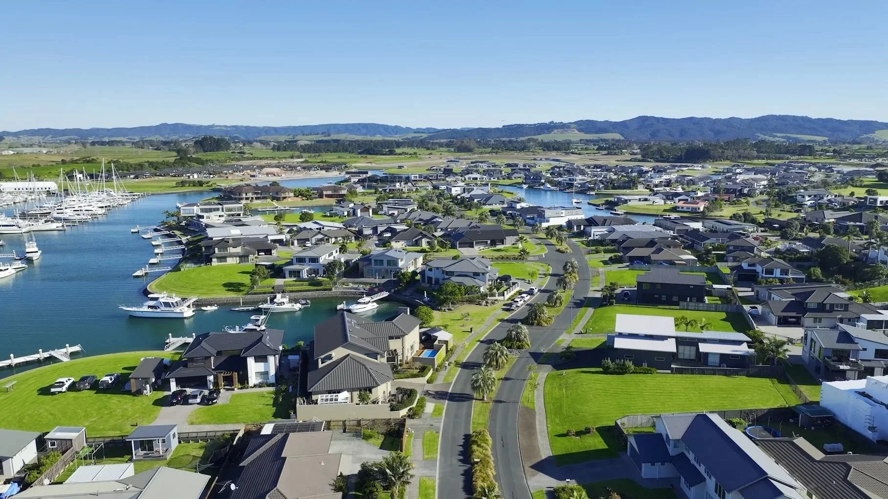 Stunning aerial drone view of Marsden Cove Marina and canal properties, showcasing the premium One Tree Point lifestyle. Sell your Bream Bay property with James Alexander and Charlotte Daun.