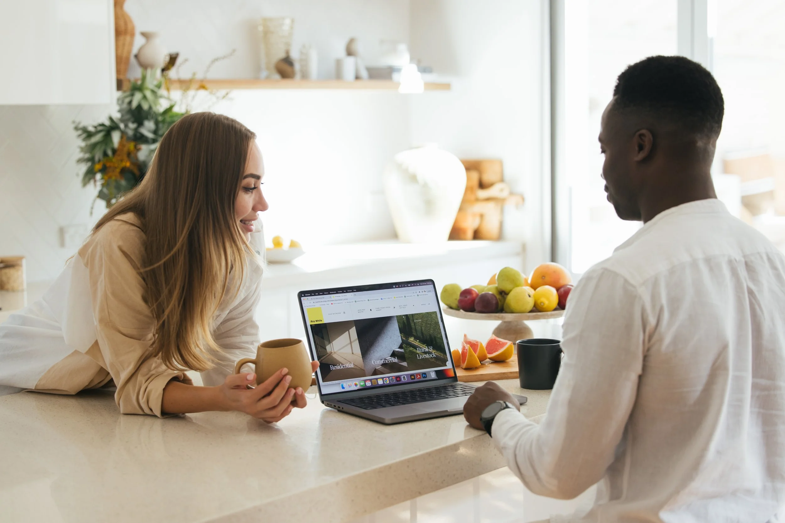 Homeowners reviewing their digital property listing and online campaign performance with a laptop, illustrative of marketing strategies. Sell your Bream Bay property with James Alexander and Charlotte Daun.