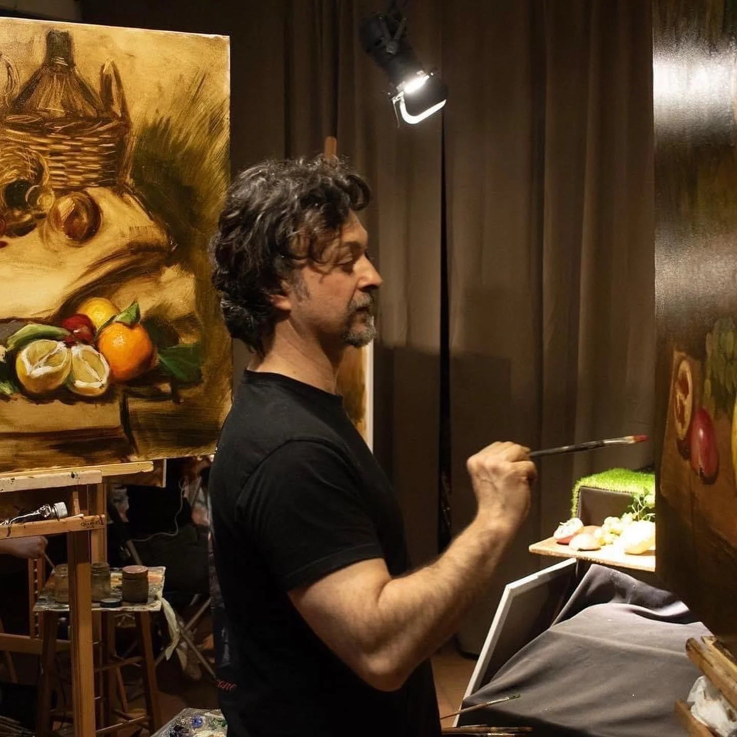 Un uomo che dipinge un quadro di frutta in uno studio d'arte.