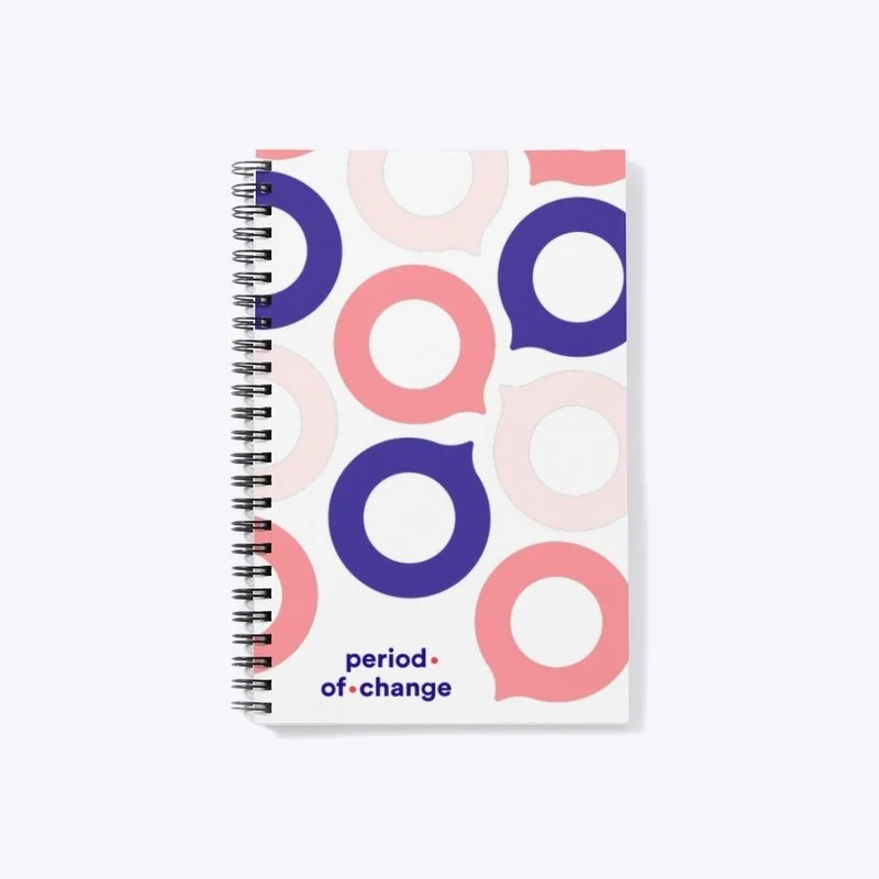 Notizbuch mit einem farbenfrohen Muster aus rosa und dunkelblauen Kreisen und dem Text "Periode des Wandels" auf der Vorderseite.