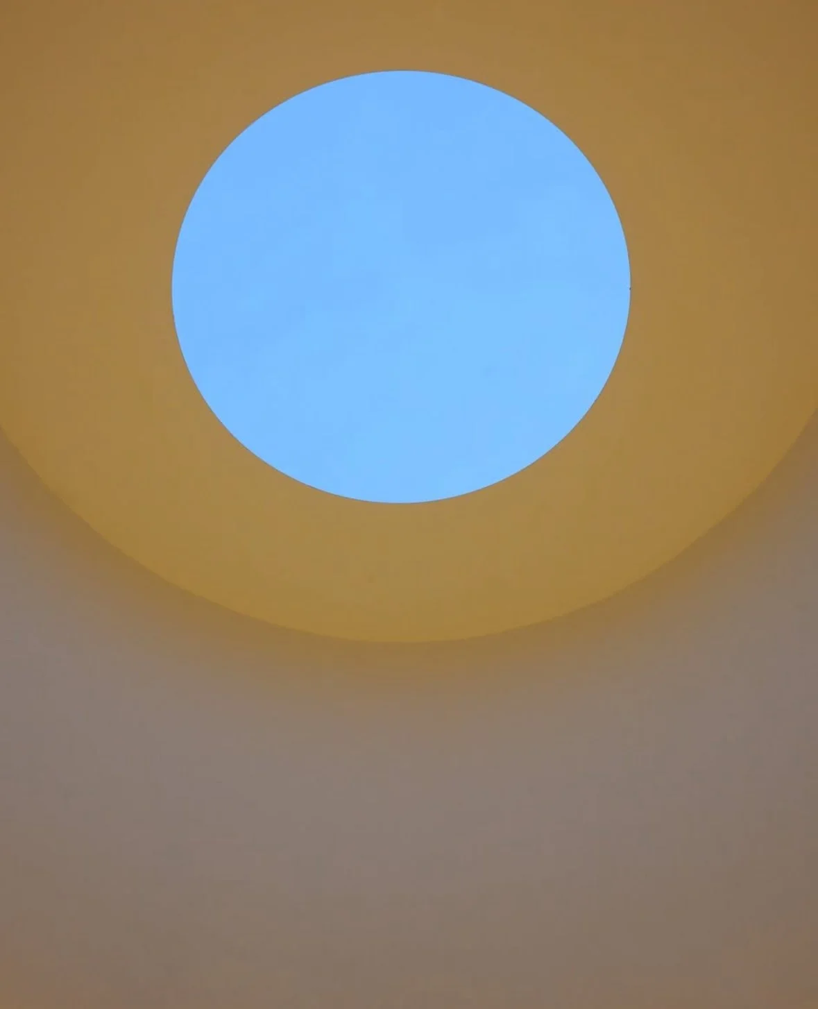 Close-up view of a ceiling light fixture with a circular blue and yellow design.