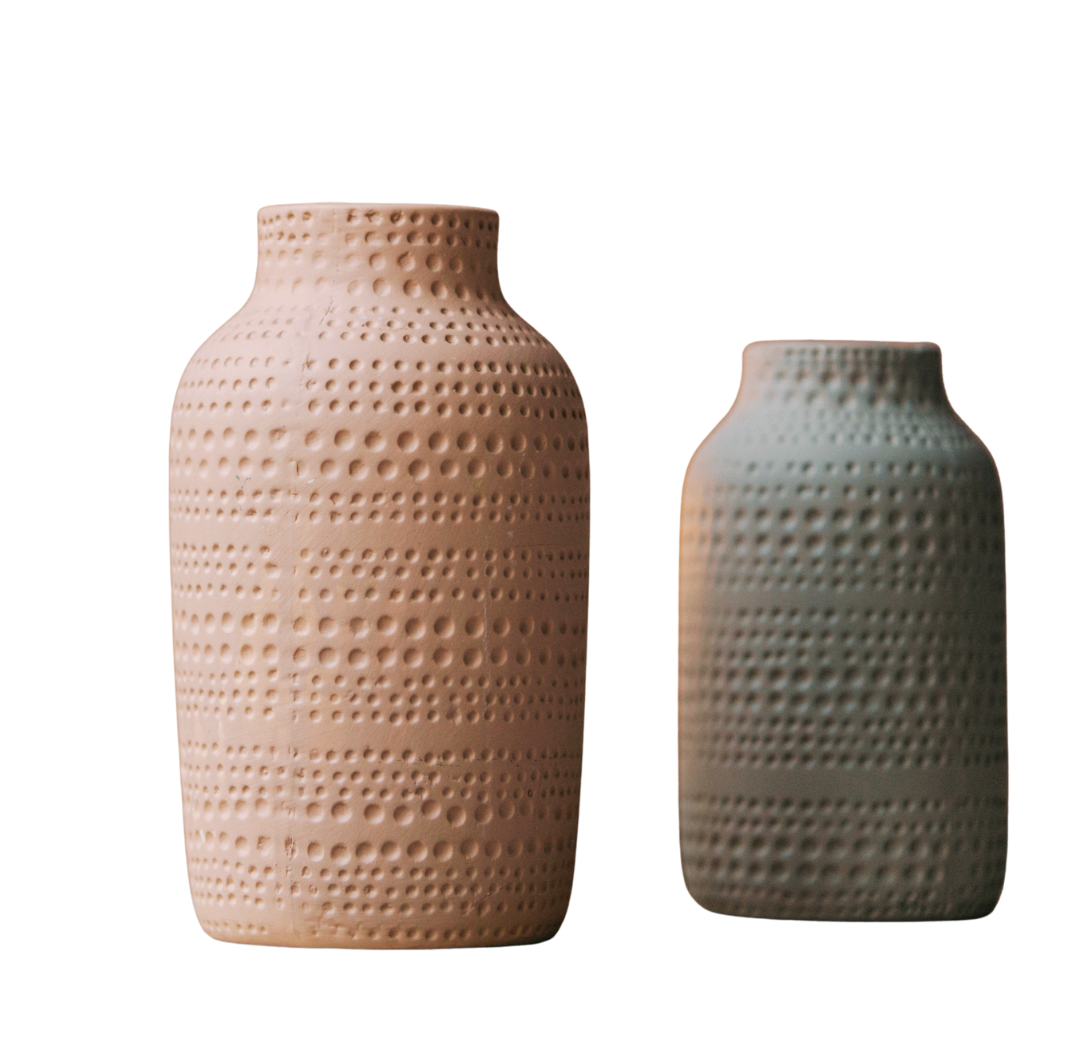 Two textured ceramic vases with dotted patterns against a cut-out background.