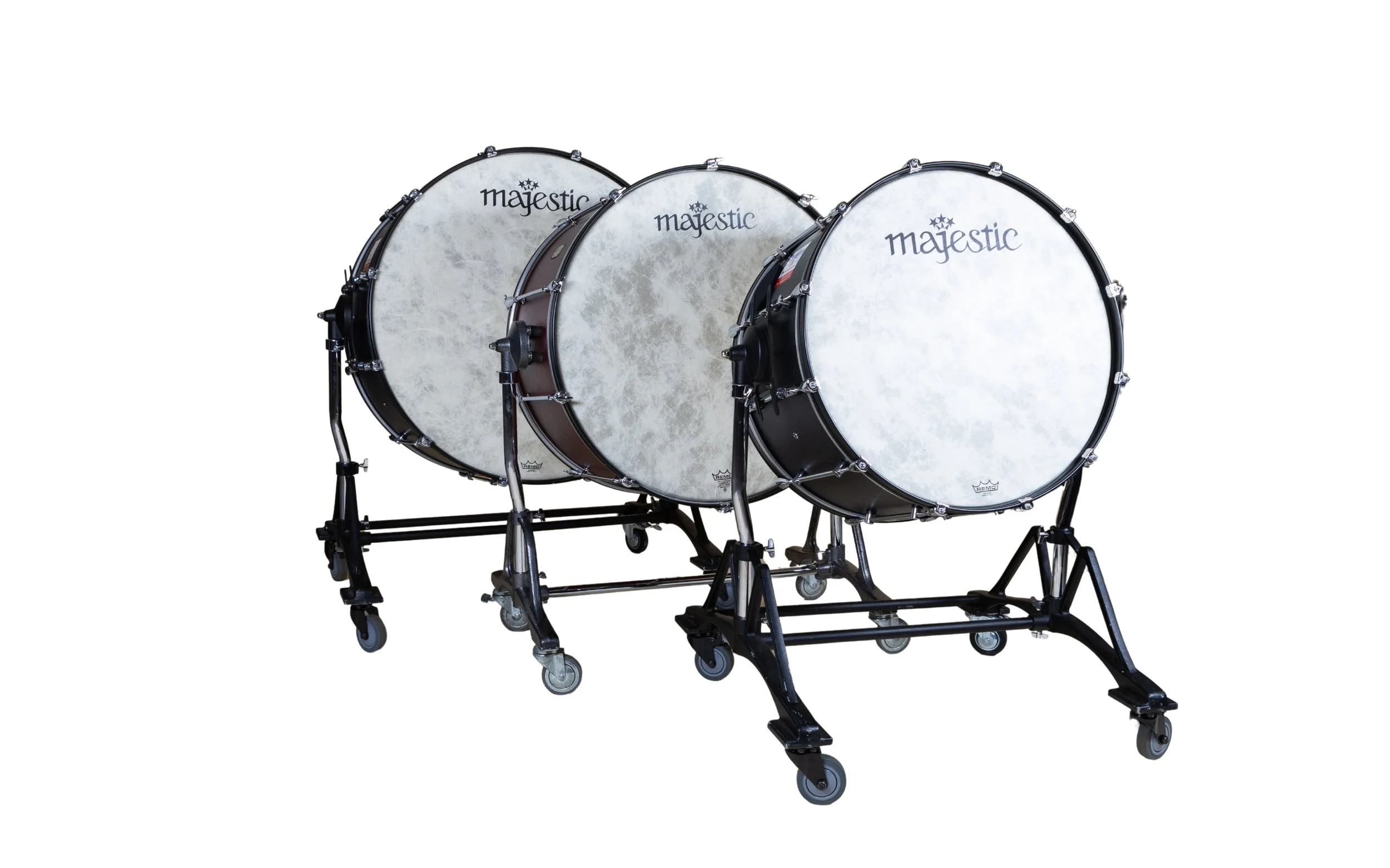 Three marching band bass drums on wheeled stands, branded 'Majestic'.
