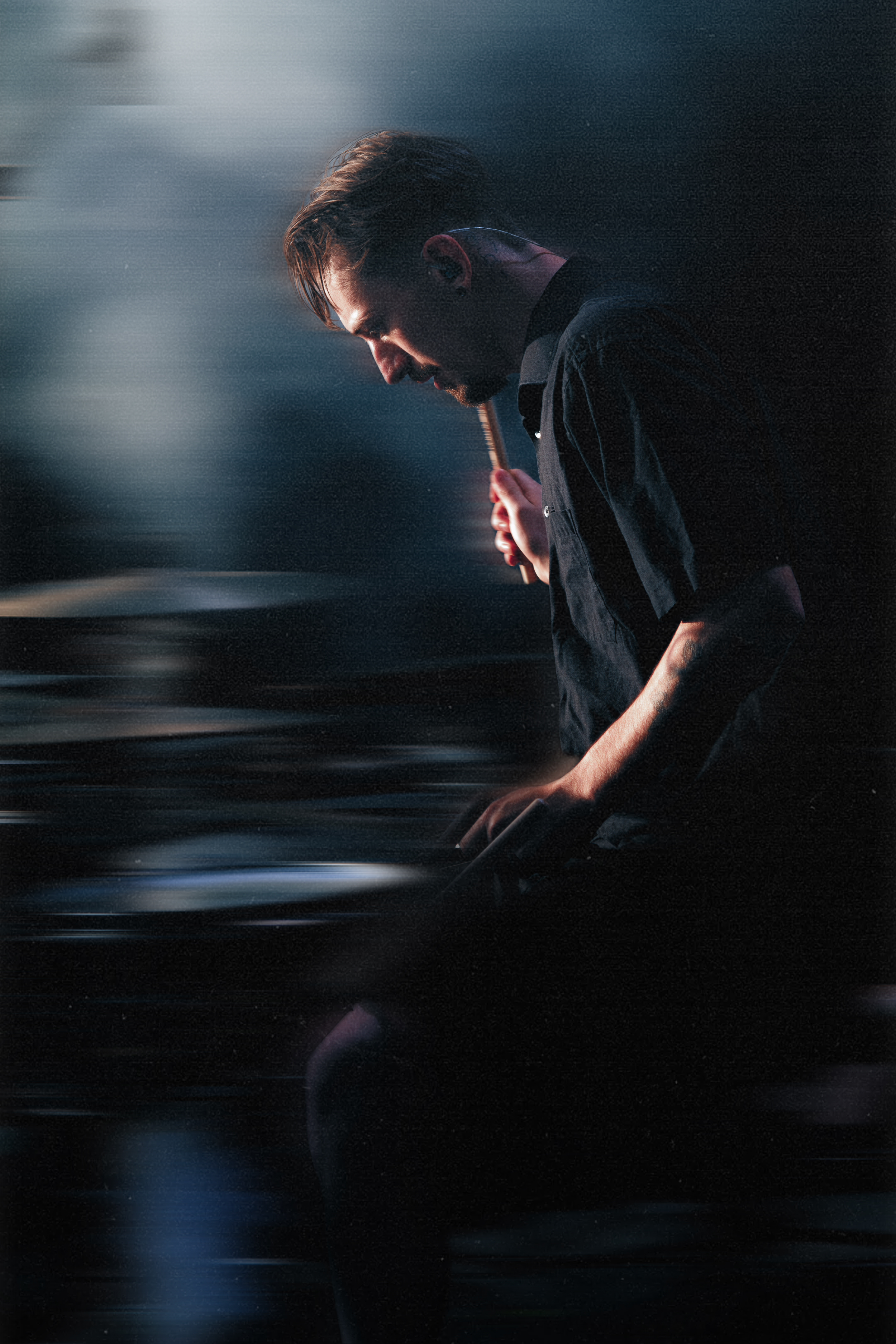 Polar Shift promotional photo featuring band member holding a hammer in a dark artistic setting.