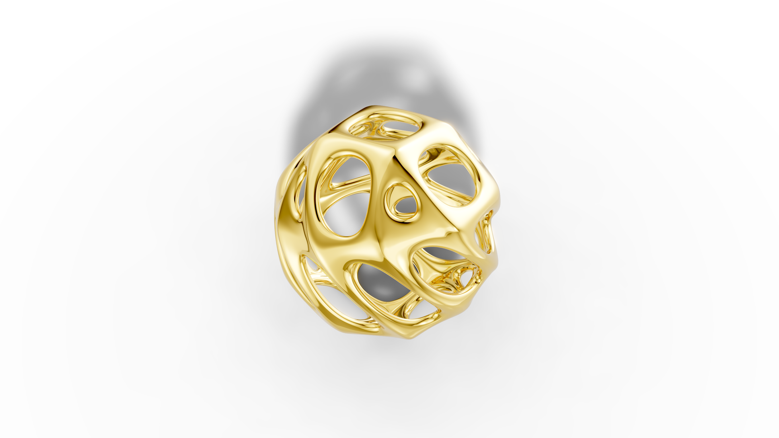 A shiny gold geometric sculpture with interconnected circular openings, placed on a white surface.