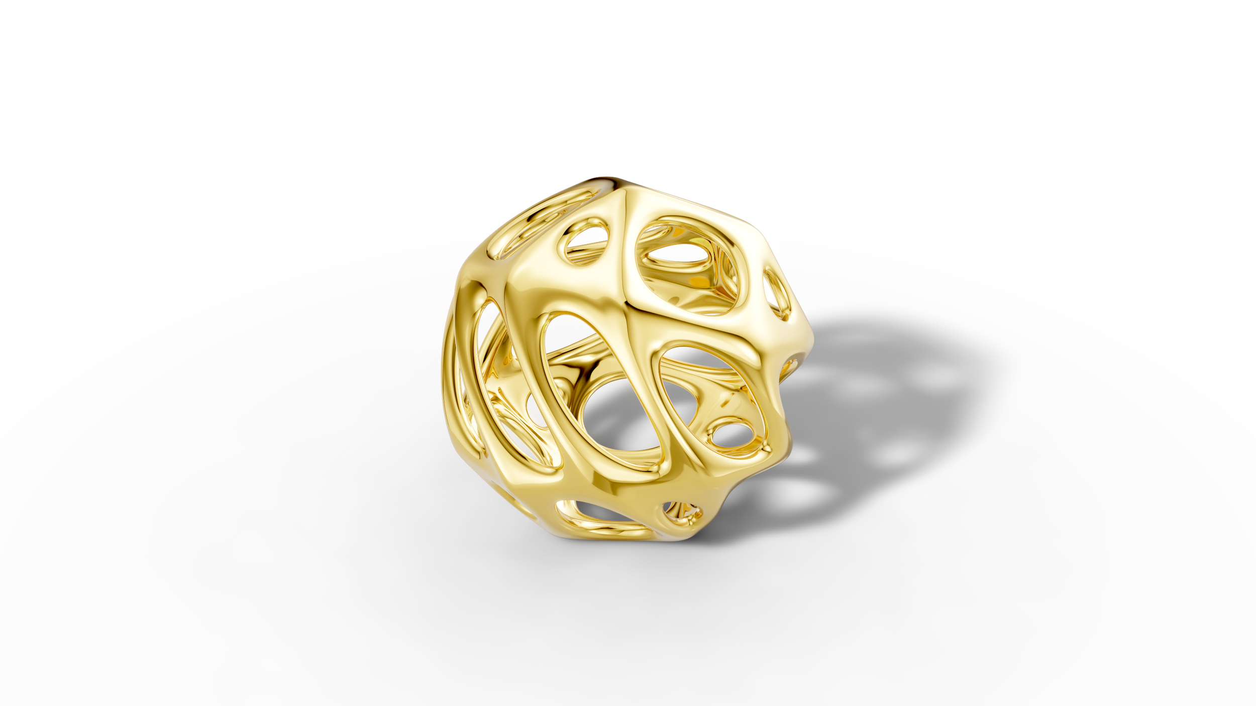A shiny gold geometric sculpture with a complex, open, lattice-like structure, placed on a white surface.