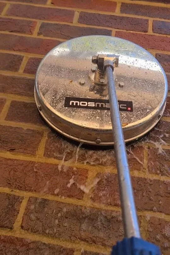 Image of a mosmatic professional soft washing machine being used by Immaculate Services in Reading to clean moss and algae from exterior wall, protecting and preserving it