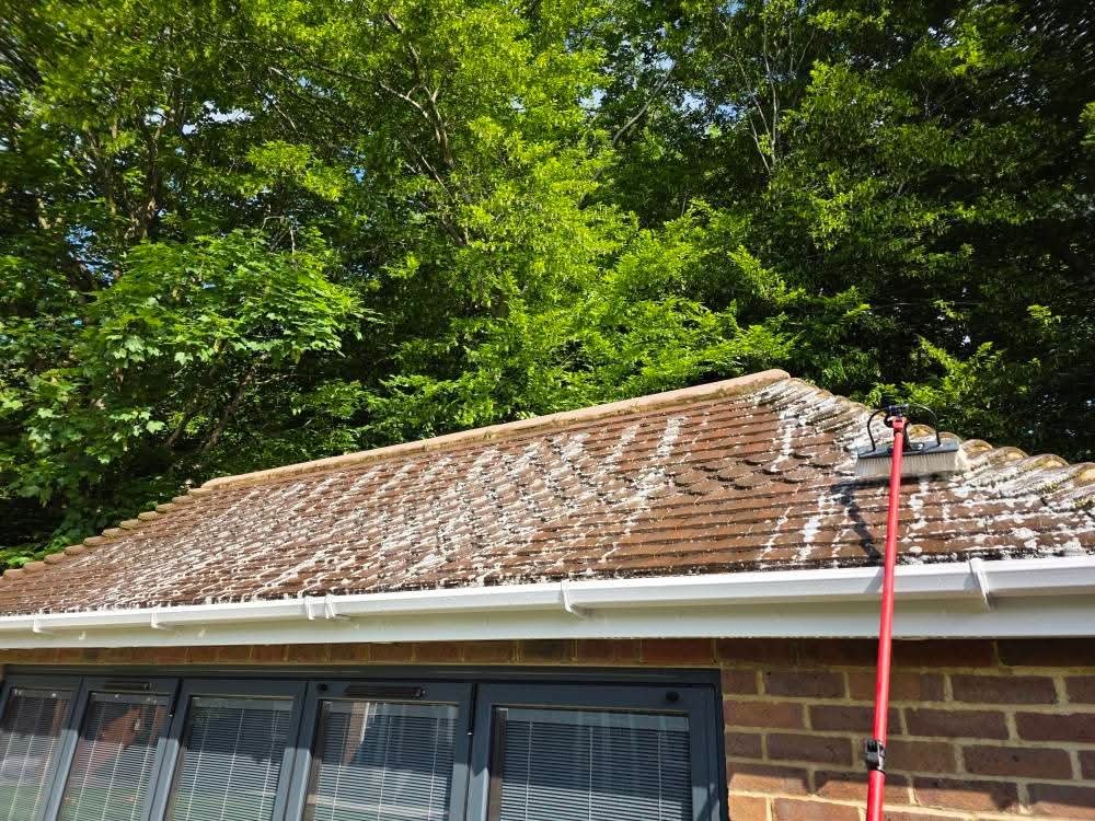 Restored roof tiles following professional cleaning. Before and after shot showing the transformation of pressure washing in the middle of a roof clean.