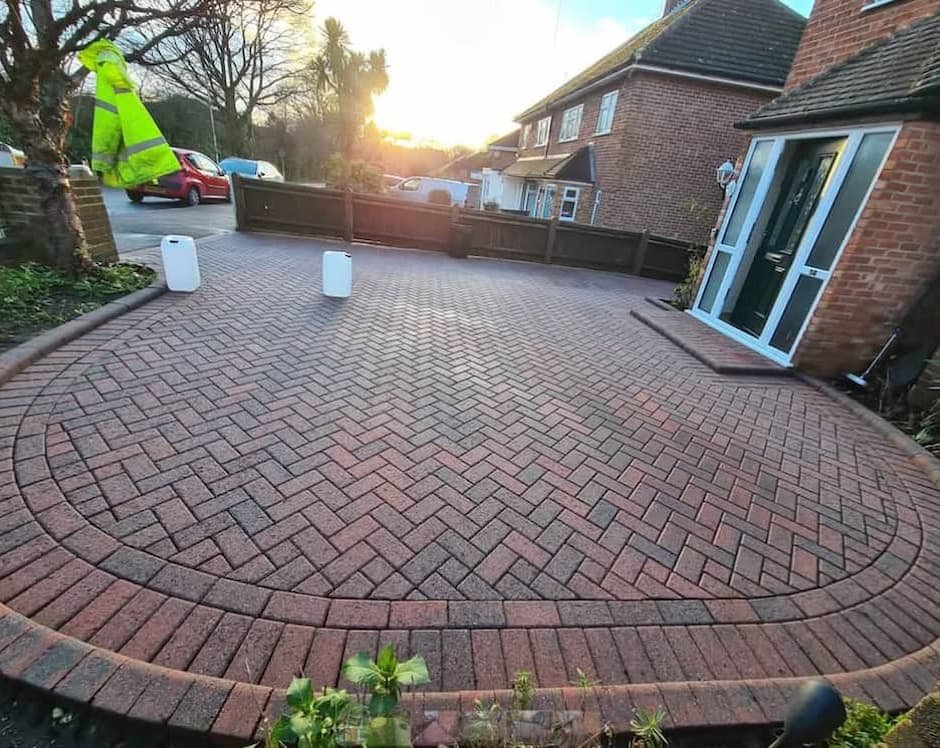 Clean and restored red herringbone block paving side driveway after deep pressure washing and re-sanding in Woodley.