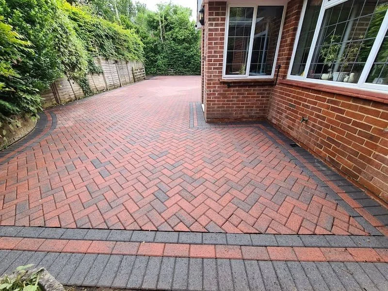 Clean and restored red herringbone brick driveway after professional pressure washing and kiln-dried re-sanding in Wokingham.