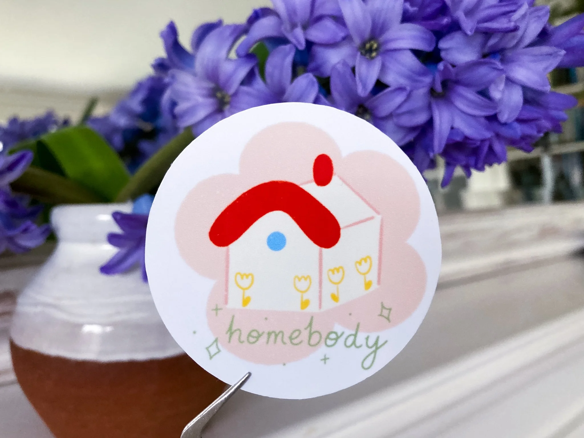 Circular sticker of a house with a red roof illustration