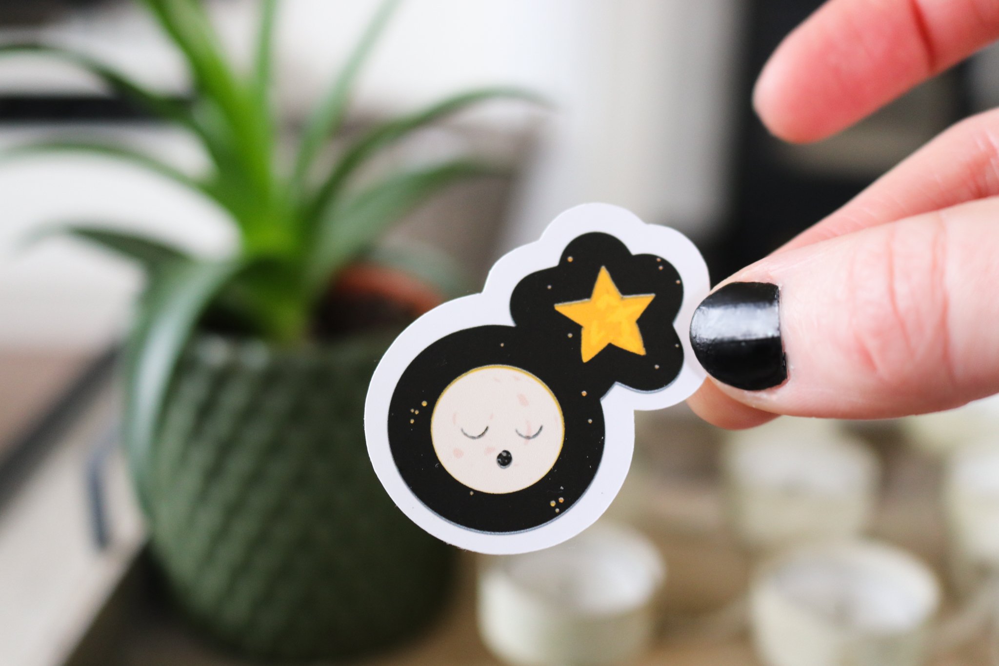 Sticker of a white moon and yellow star on a black background