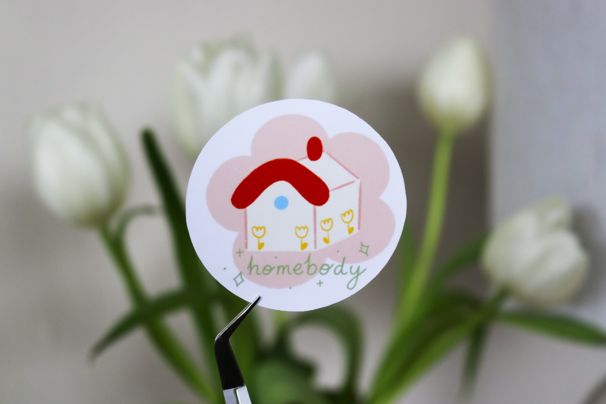 Round sticker of a simple house with yellow flowers illustration