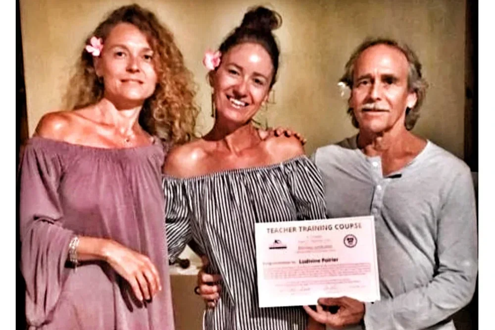Trois personnes souriantes, deux femmes et un homme, posent avec un certificat de formation pour enseignants.