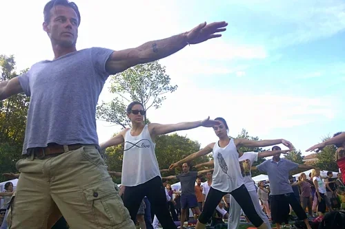 Groupe de personnes pratiquant le yoga en plein air.